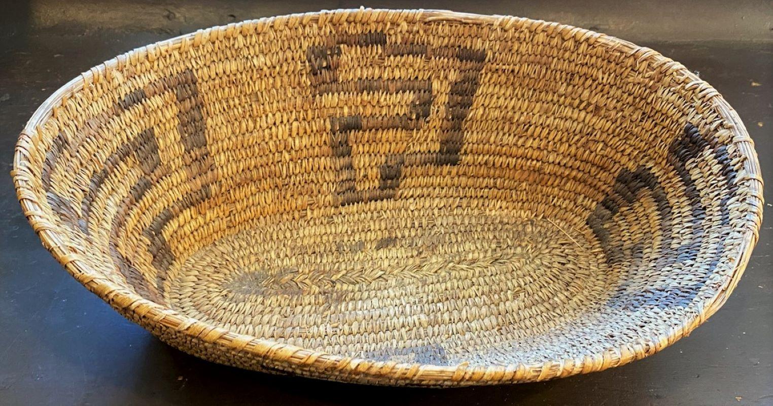This fine papago Indian weaving basket isin good condition with minor wear on the top trim area in two spots. See pics. This is quite unusual the oval shape.