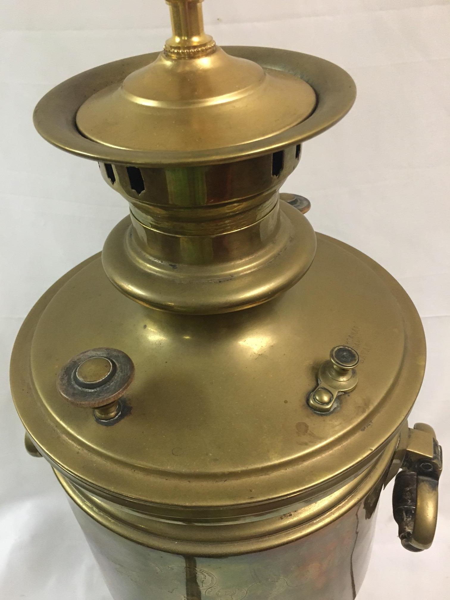 Este gran Samovar Ruso clásico de latón presenta varios sellos de calidad estampados en la parte delantera, robustas asas de madera y descansa sobre una base cuadrada de cuatro patas. Se ha convertido en una lámpara de trabajo. El samovar en sí mide