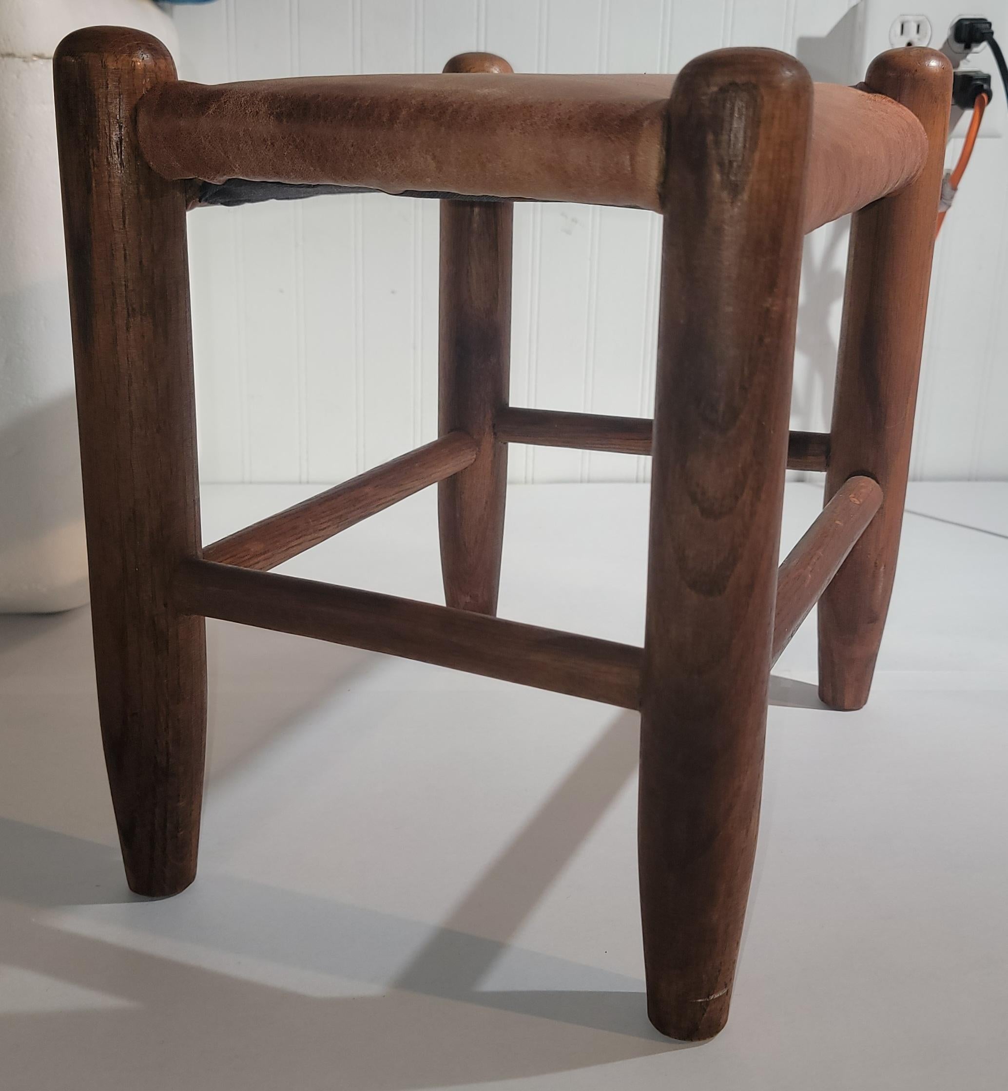 This fine strong & sturdy stool has a distressed leather seat or top.It is in fine condition.