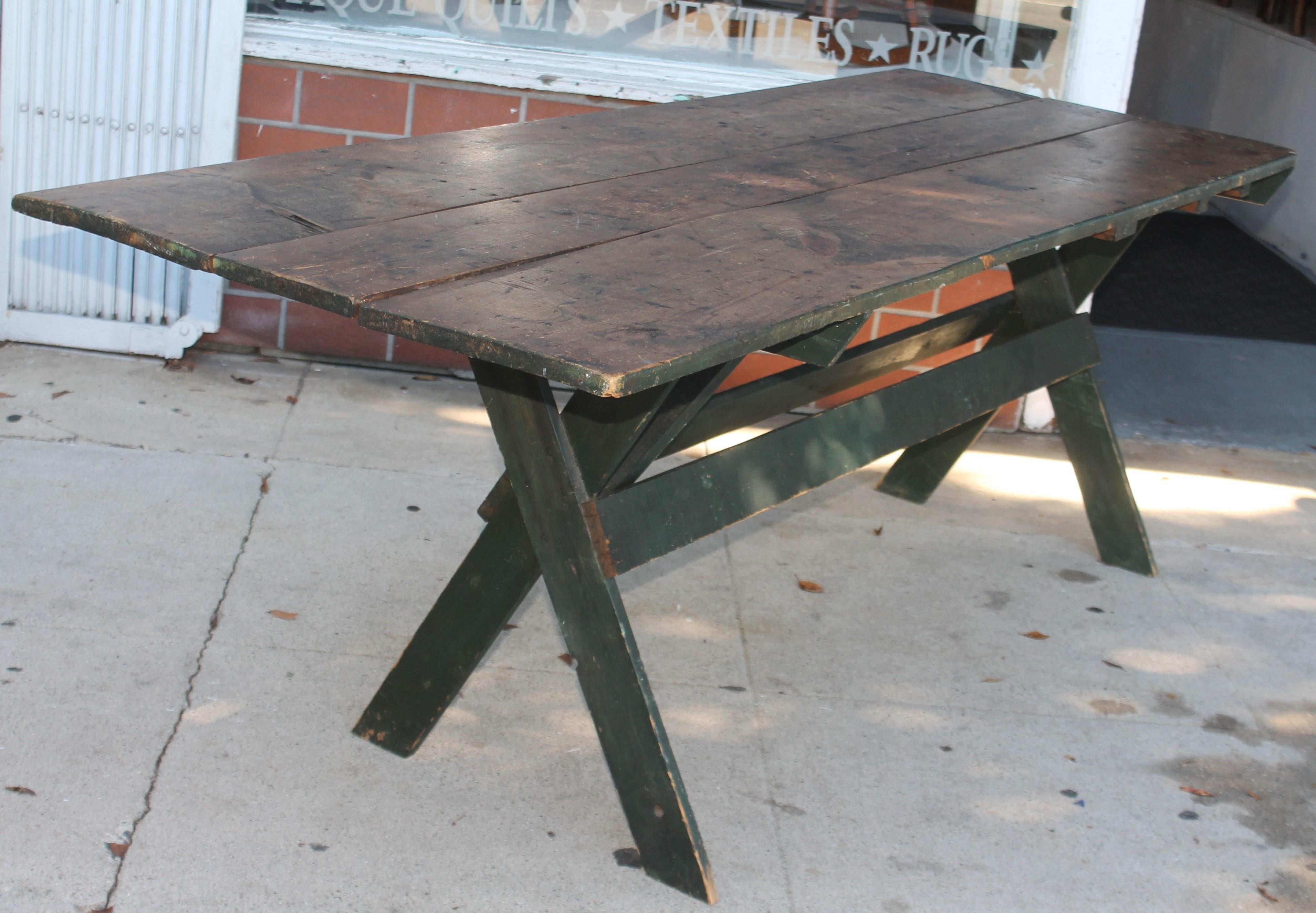 This fantastic over sized sawbuck table in original painted surface. The surface is amazing and undisturbed surface. This is a original painted base and a original scrub top. The construction is square nailed and wood pegs.