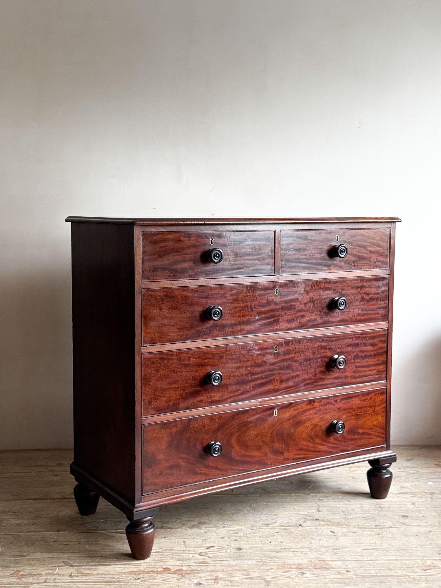 A very fine quality, early 19thC mahogany chest of drawers. Raised on elongated bun or melon feet with an arrangement of two over three drawers, with turned knobs and working locks. The top has a moulded handle she and overhang at the rear to allow