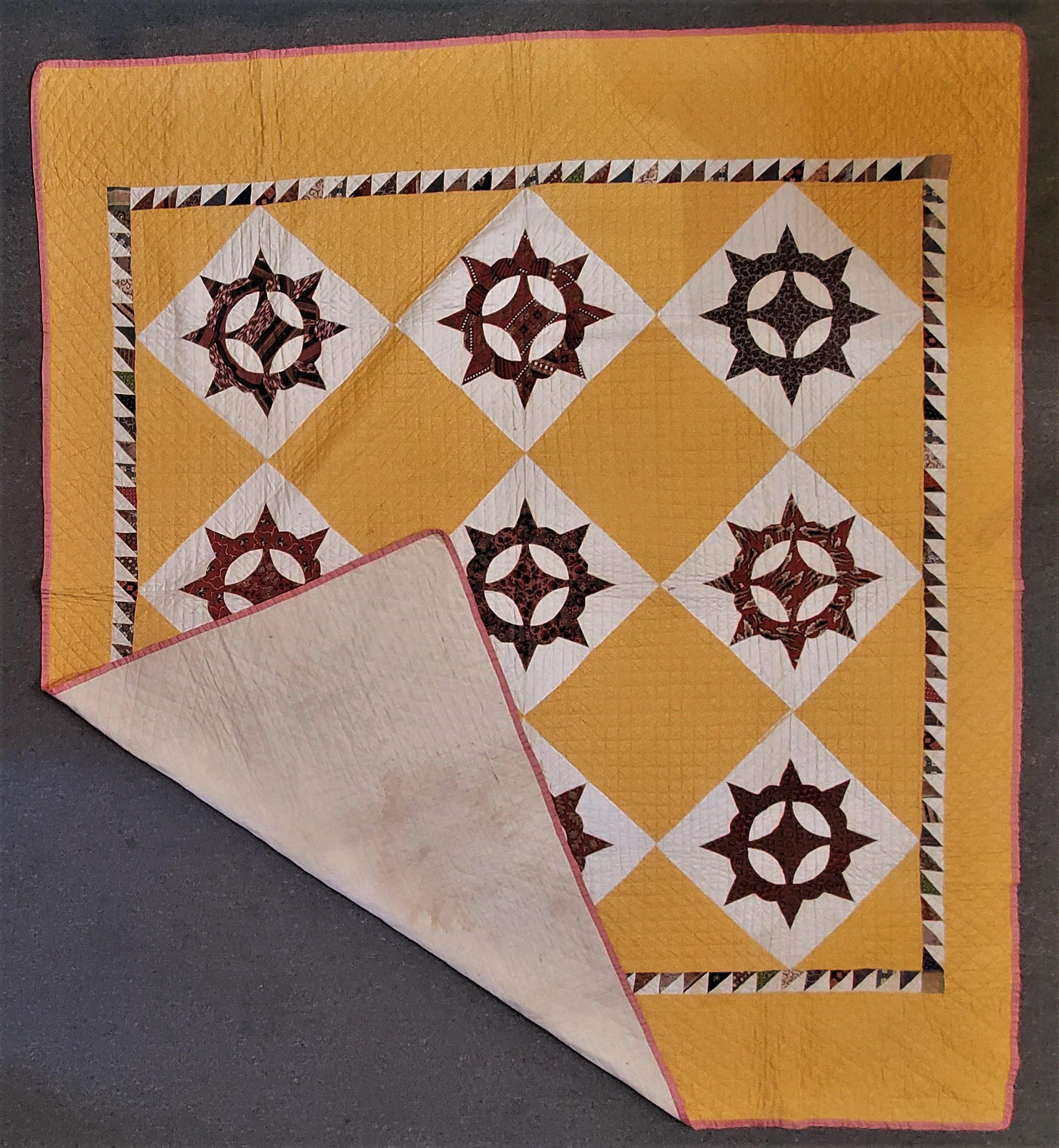 This fine and early unusual pattern Mariners compass wheel pattern quilt is in amazing pristine condition. The background fabric is a very rich tangerine calico fabric. The backing of the quilt is a cream unbleached muslin.
