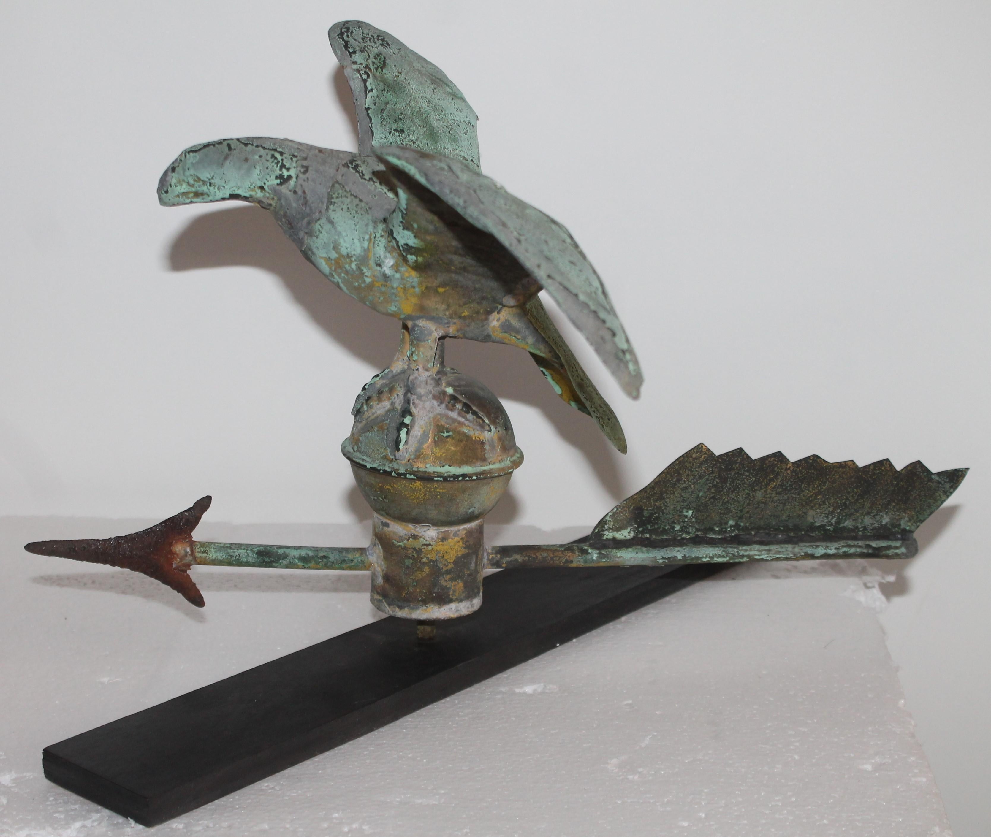 19th century Mini eagle weather vane on stand with a great patina. This fine eaglet is in very good condition. The bottom feathers of the arrow are missing. The arrow tip is in iron. This is a rare size vane.