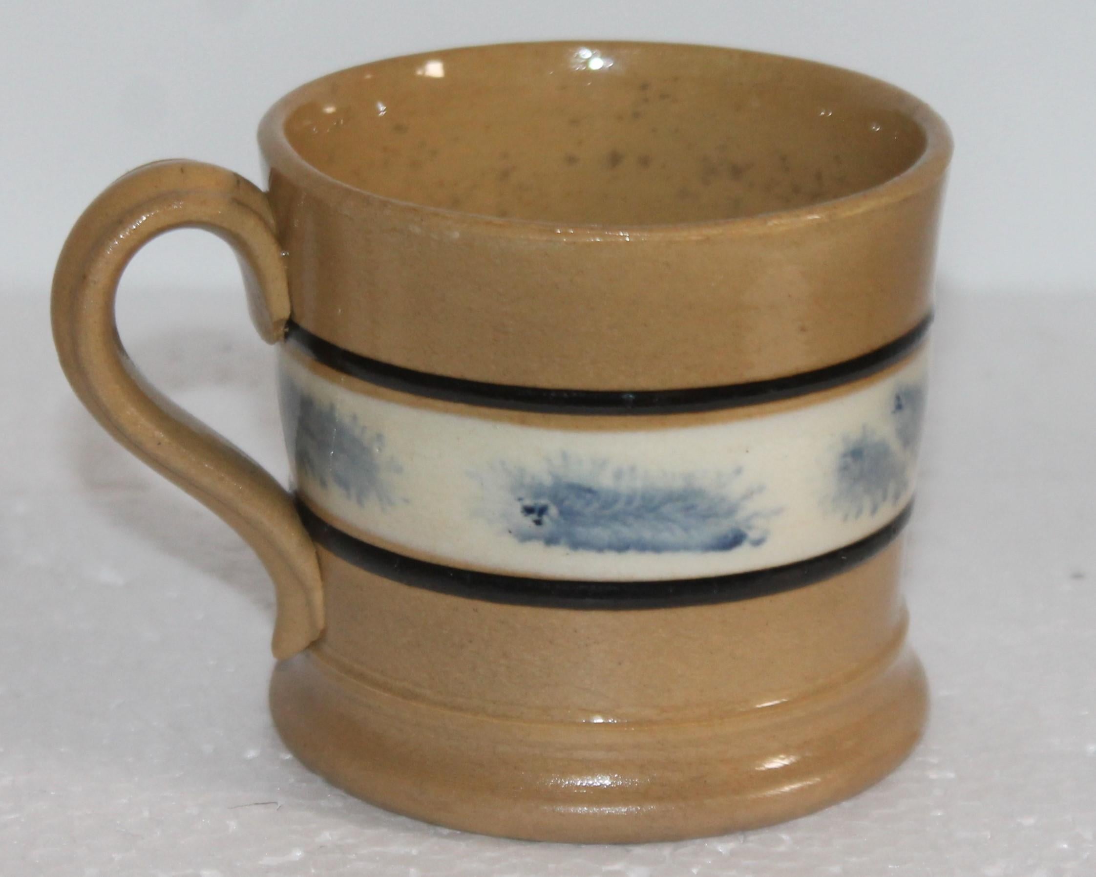 This 19th century mocha yellow ware mug with the blue sea weed pattern is in good condition. This mug has a tiny rim chip looks like its in the glaze. These mugs are super rare and hard to find in good condition.