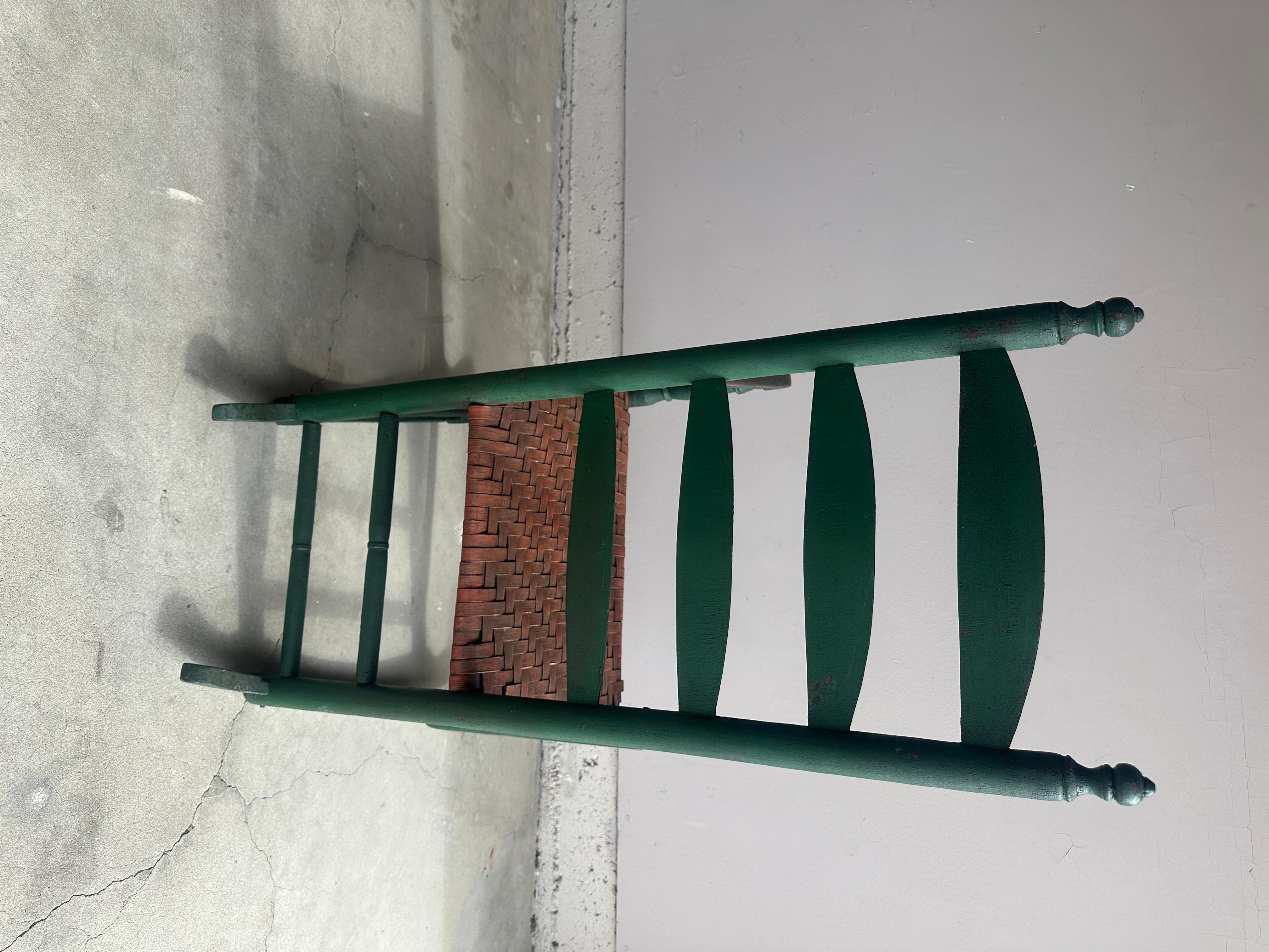 19Thc Sedia a dondolo originale con schienale a scaletta verde mela e seduta in giunco intrecciato a mano con vernice salmone. Questa sedia a dondolo del primo New England è in ottime condizioni e molto robusta.
La superficie dipinta è tutta