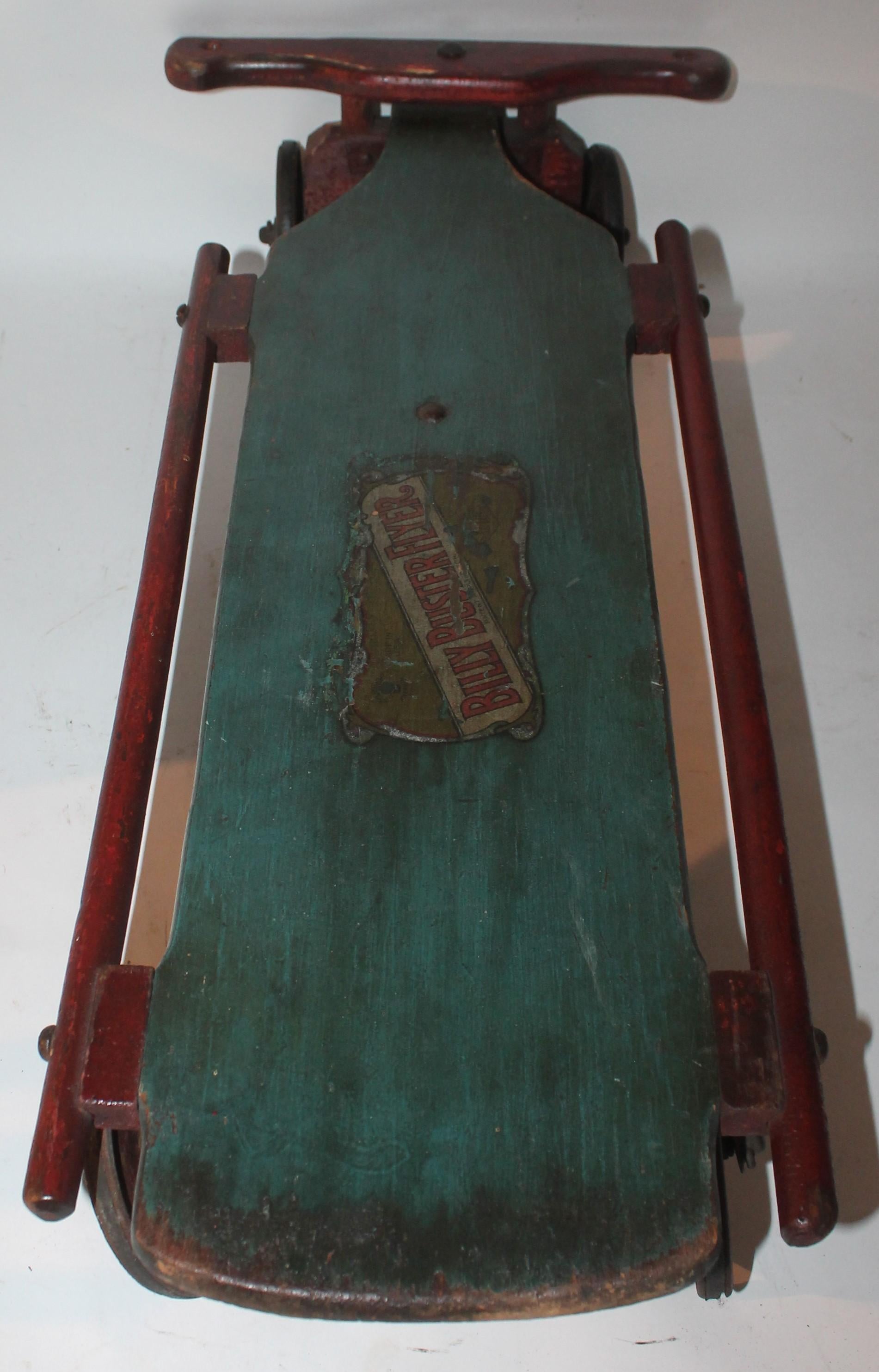 19th century original painted Billy buster flyer sled with wheels. The toy is painted blue & red wood with tin wheels. The condition is all original and very strong in working order.