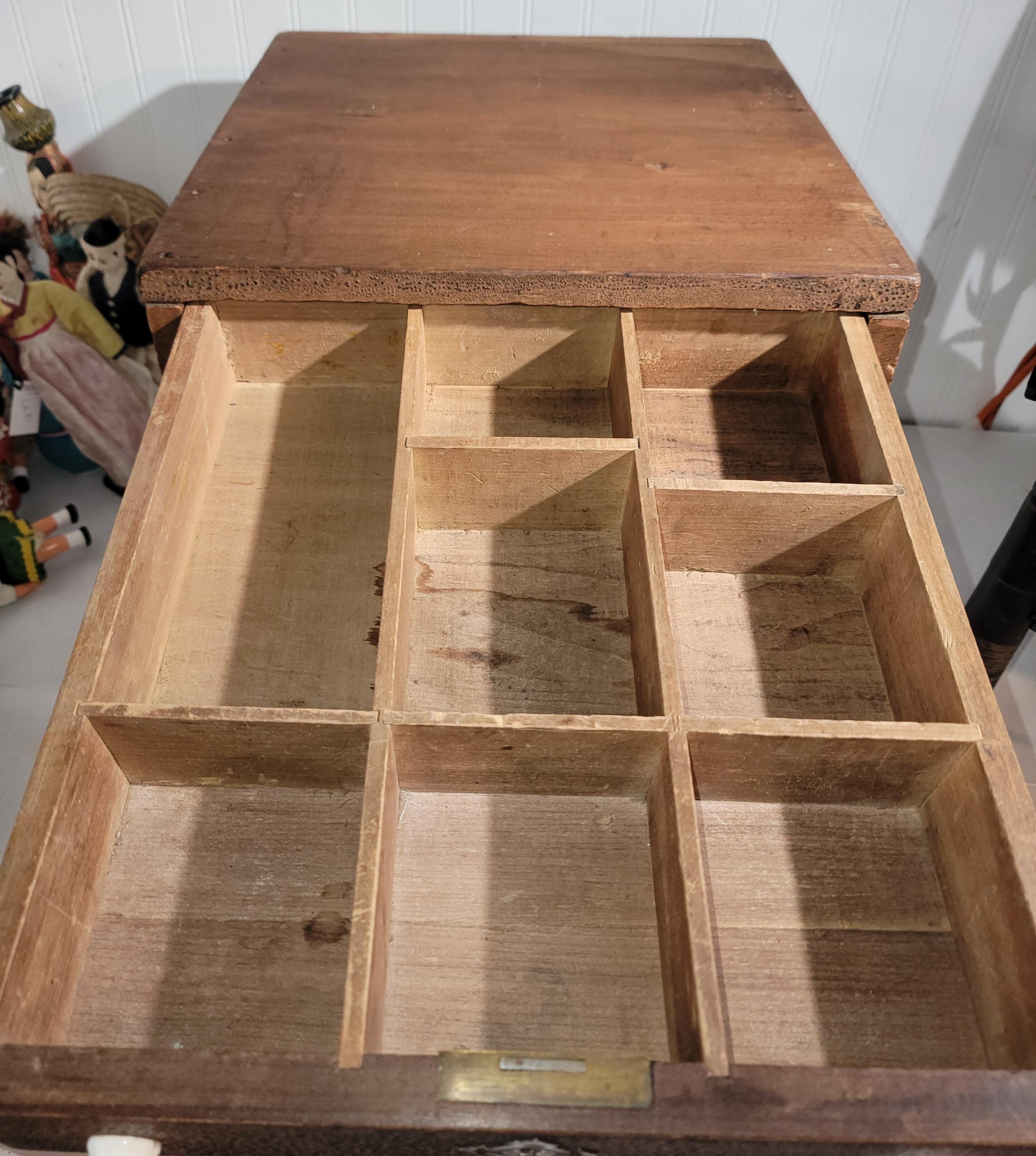This is either a 19thc hardware drawer box or a cash drawer of sorts.The construction is early cut nails and a dovetailed drawer.There is a brass & iron handle on the side of the box for carrying from place to place.There is a key hole in the front