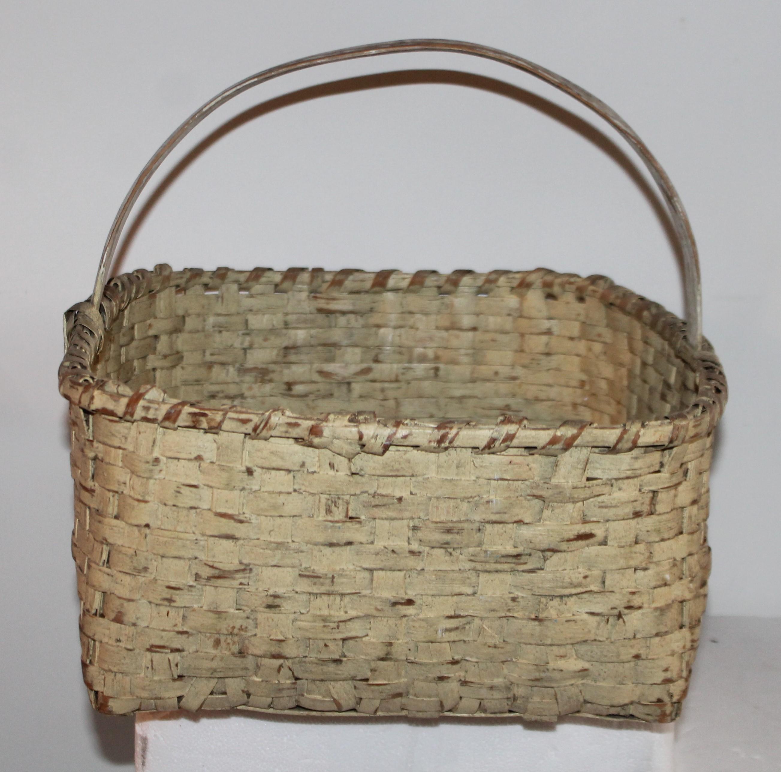 19th century original creamy yellow painted gathering basket from New England. This fine folky basket has the original cream painted handle and yellow bottom.