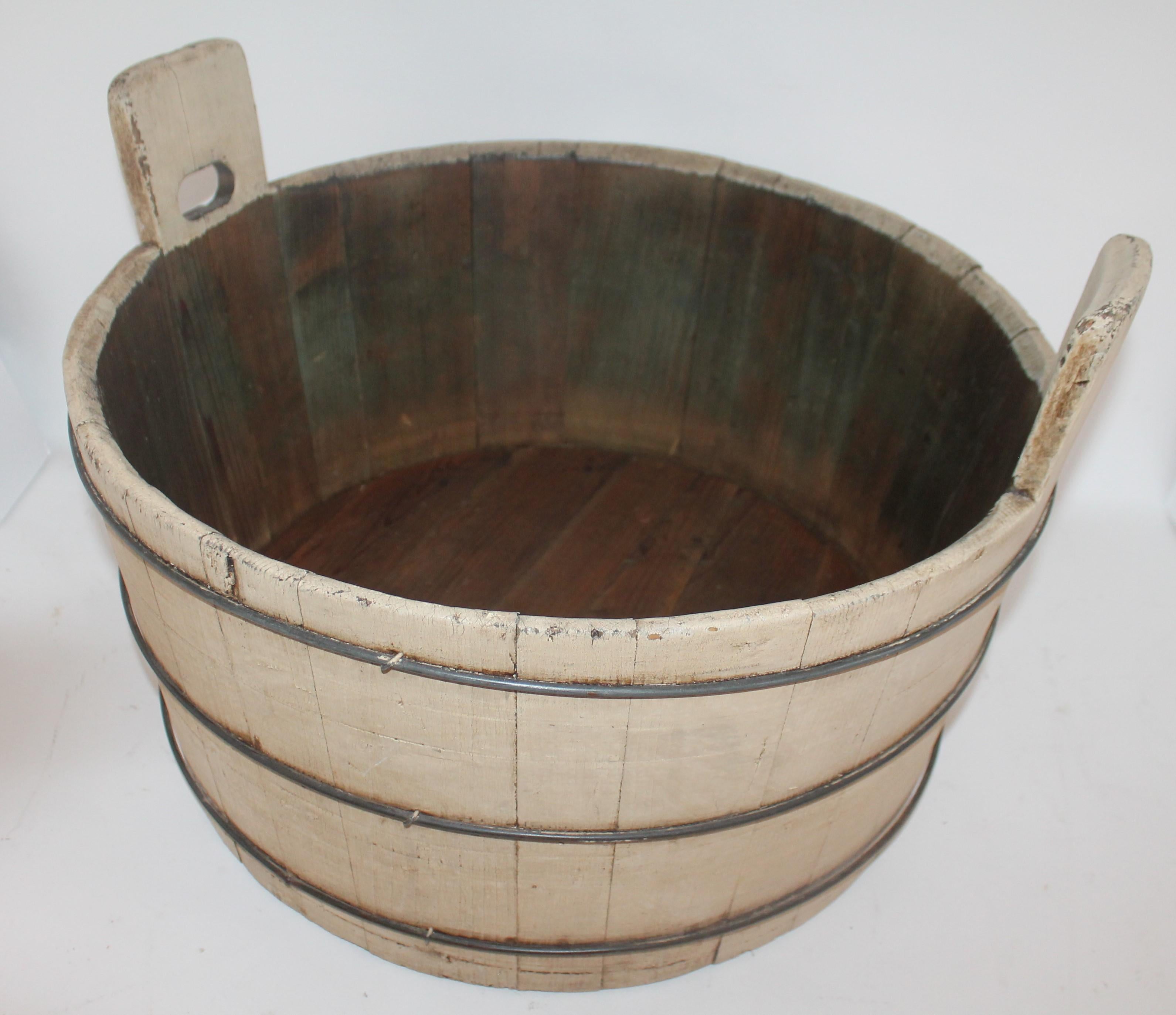 This Shaker style wash tub has double handles and is in sturdy tight condition. The patina is great and it has three original security bands great for fire wood storage next to fireplace.