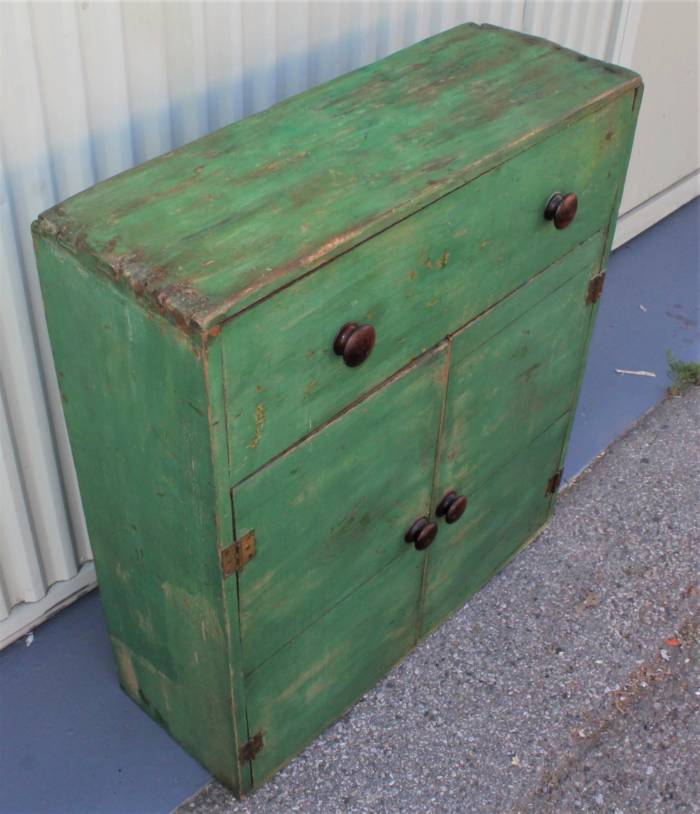 19th century original green painted dovetailed case cabinet from Pennsylvania. The condition is good with a over painted top of cabinet.
