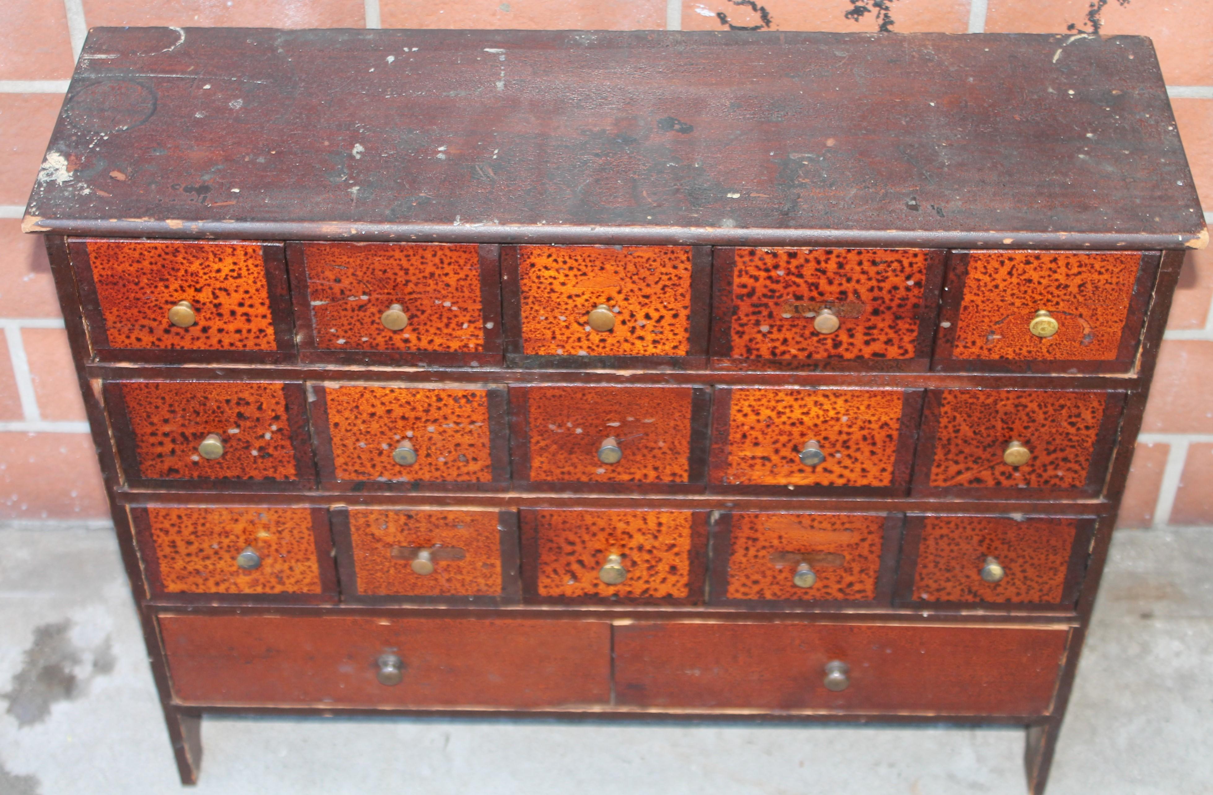 This 19thc apothecary cabinet in original painted surface and original brass pulls and cut nailed construction.This cabinet has seventeen drawers and square nailed construction.