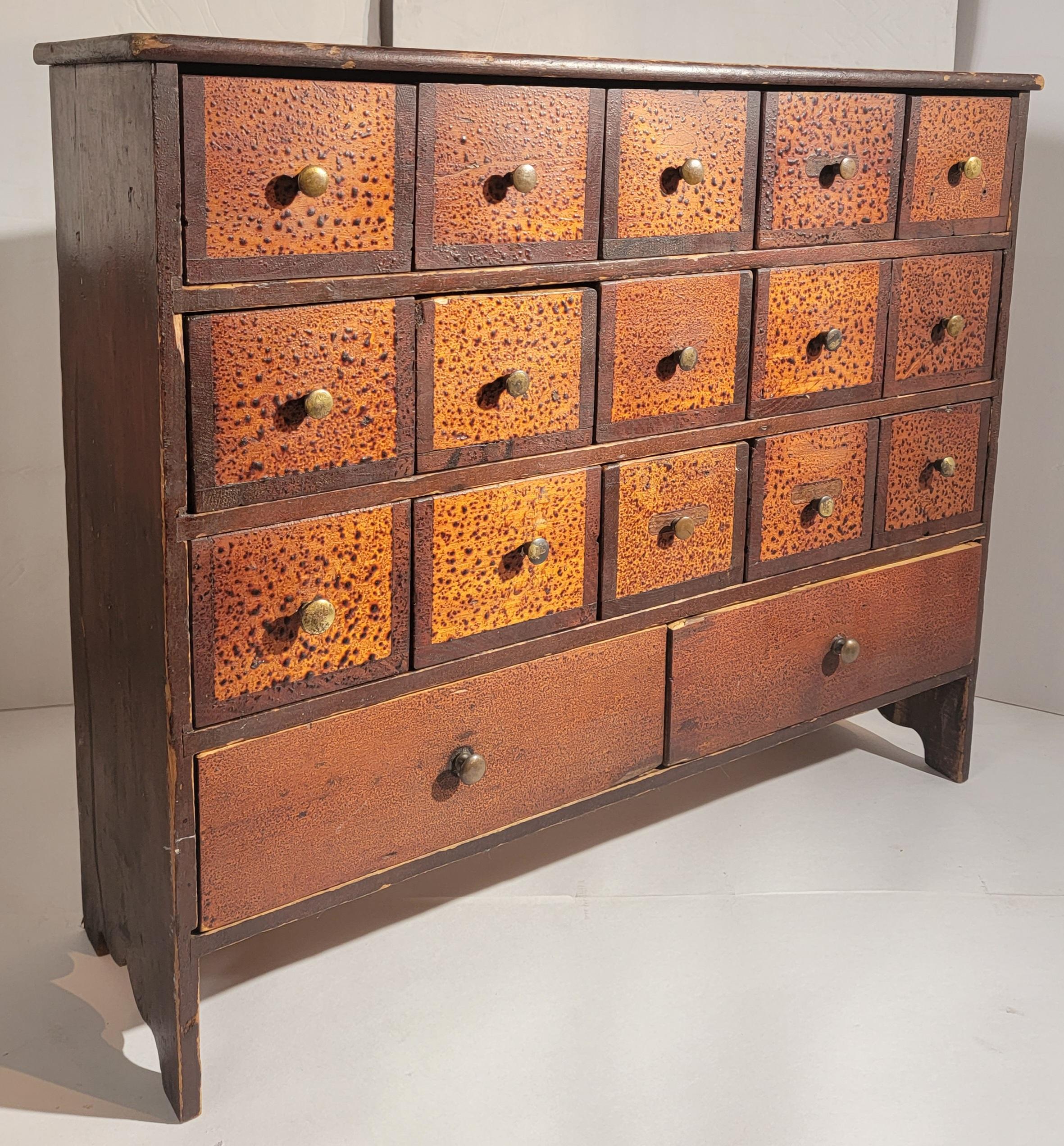 This 19thc apothecary cabinet in original painted surface and original brass pulls and cut nailed construction.This cabinet has seventeen drawers and square nailed construction.