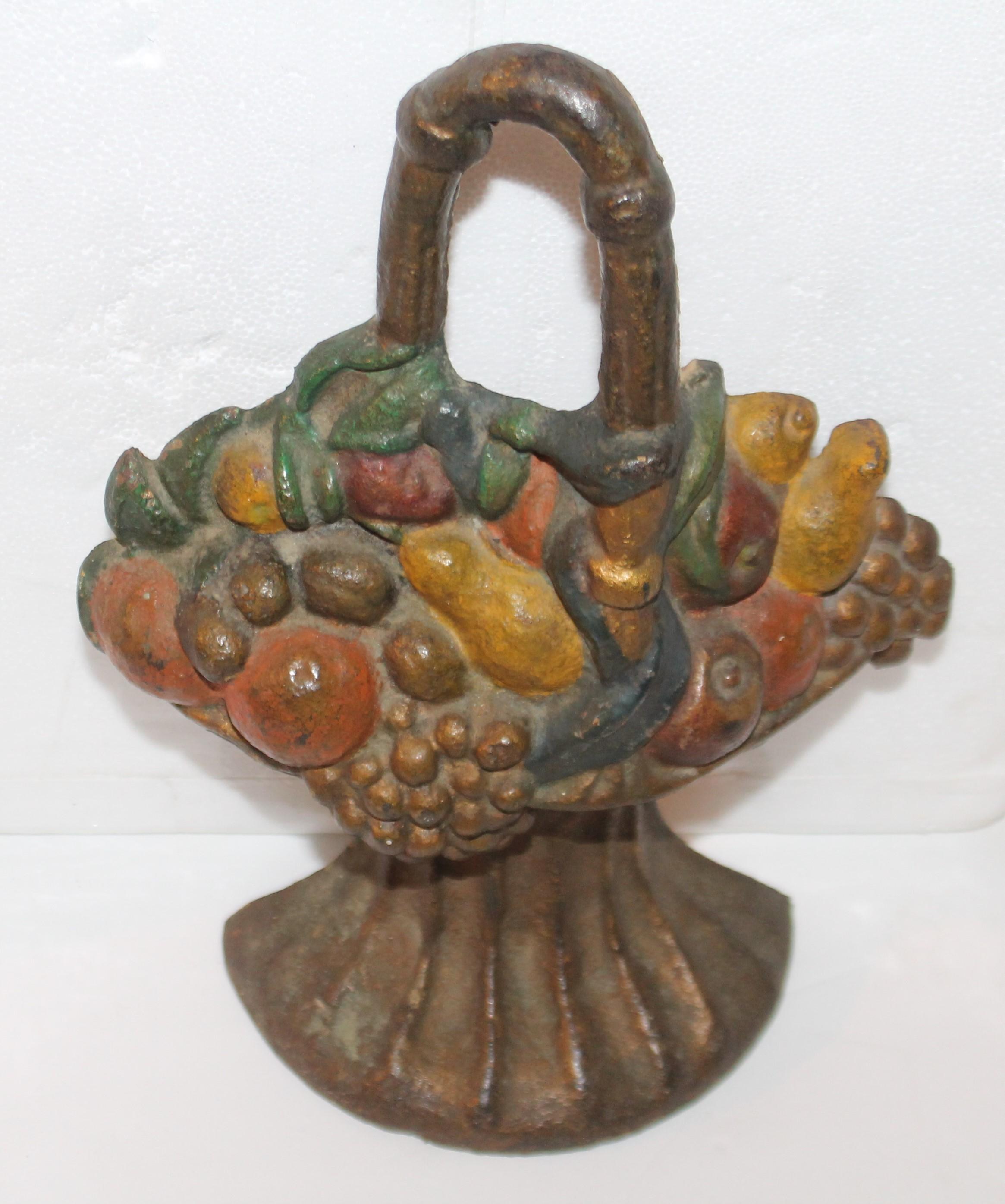 This fine cast iron door stop is in original painted surface and great condition. Really great paint. The basket is filled with vegetables and fruit.