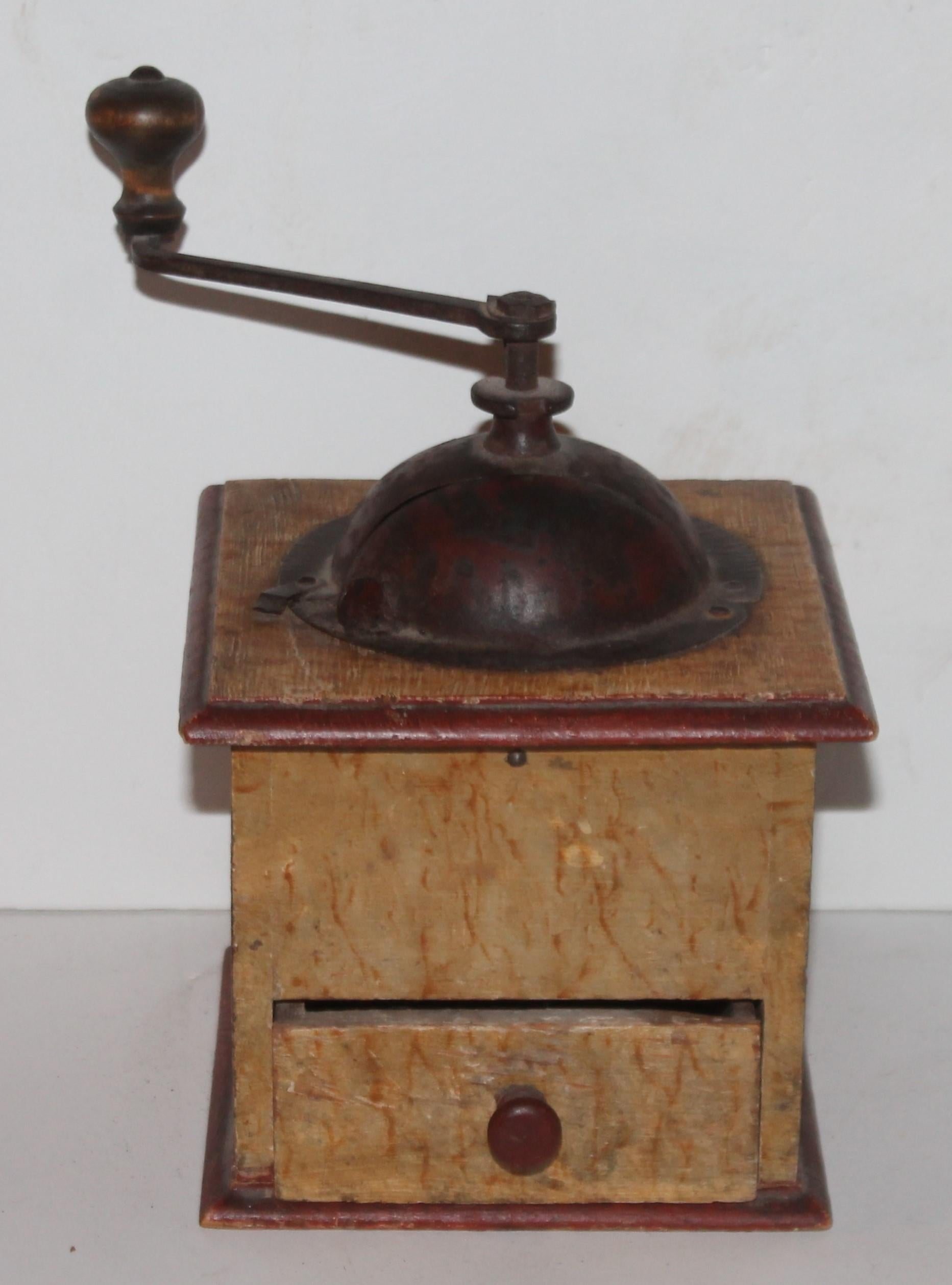 This fine original grain painted coffee grinder is in a mustard paint and trimmed in red paint. All original hardware and square nailed construction.
