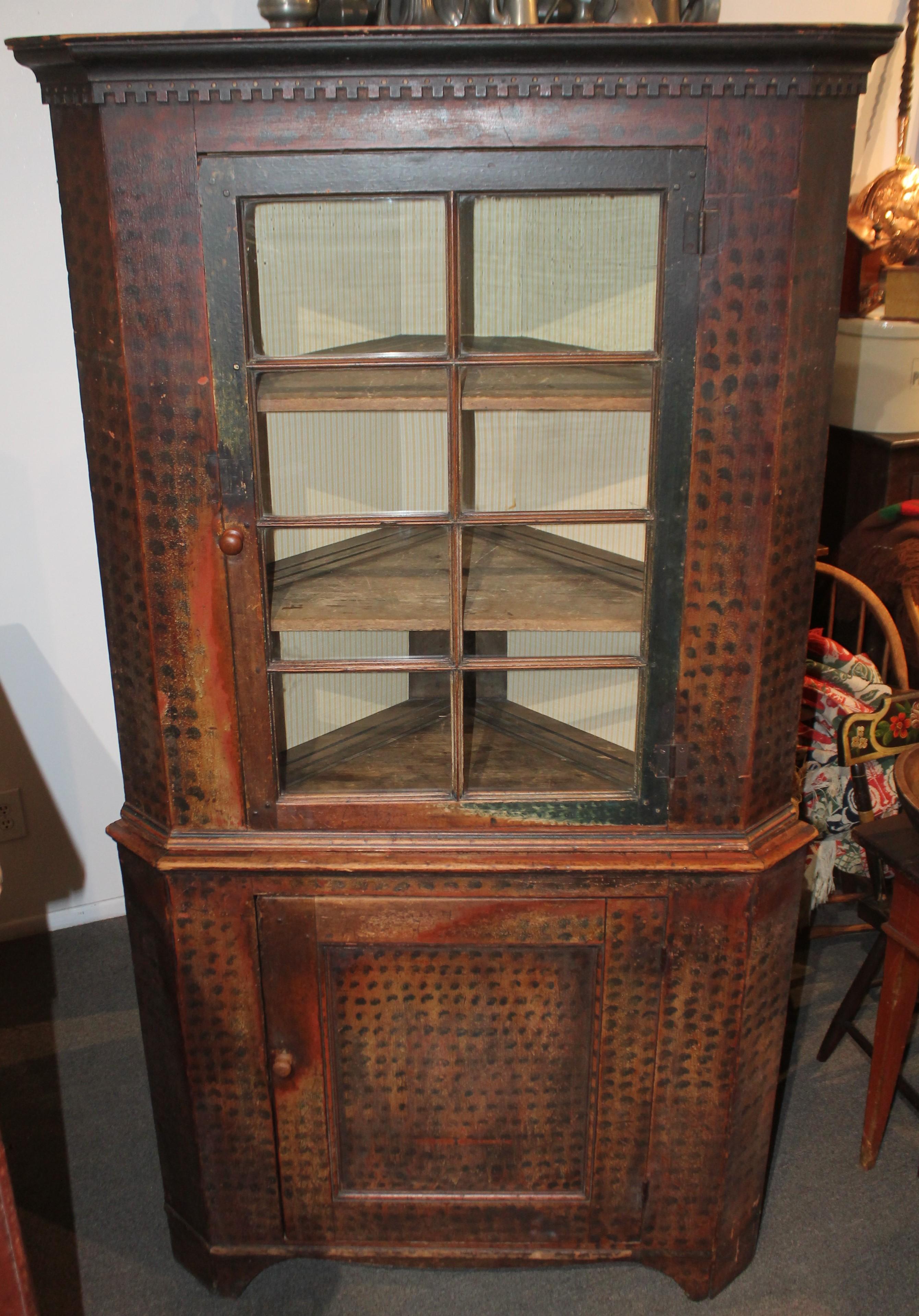 19th Century super rare original painted two-piece corner cupboard from Pennsylvania. Amazing dental crown molding and dovetailed case. This folky spotted undisturbed surface corner cupboard is in great as found condition. This comes from a private