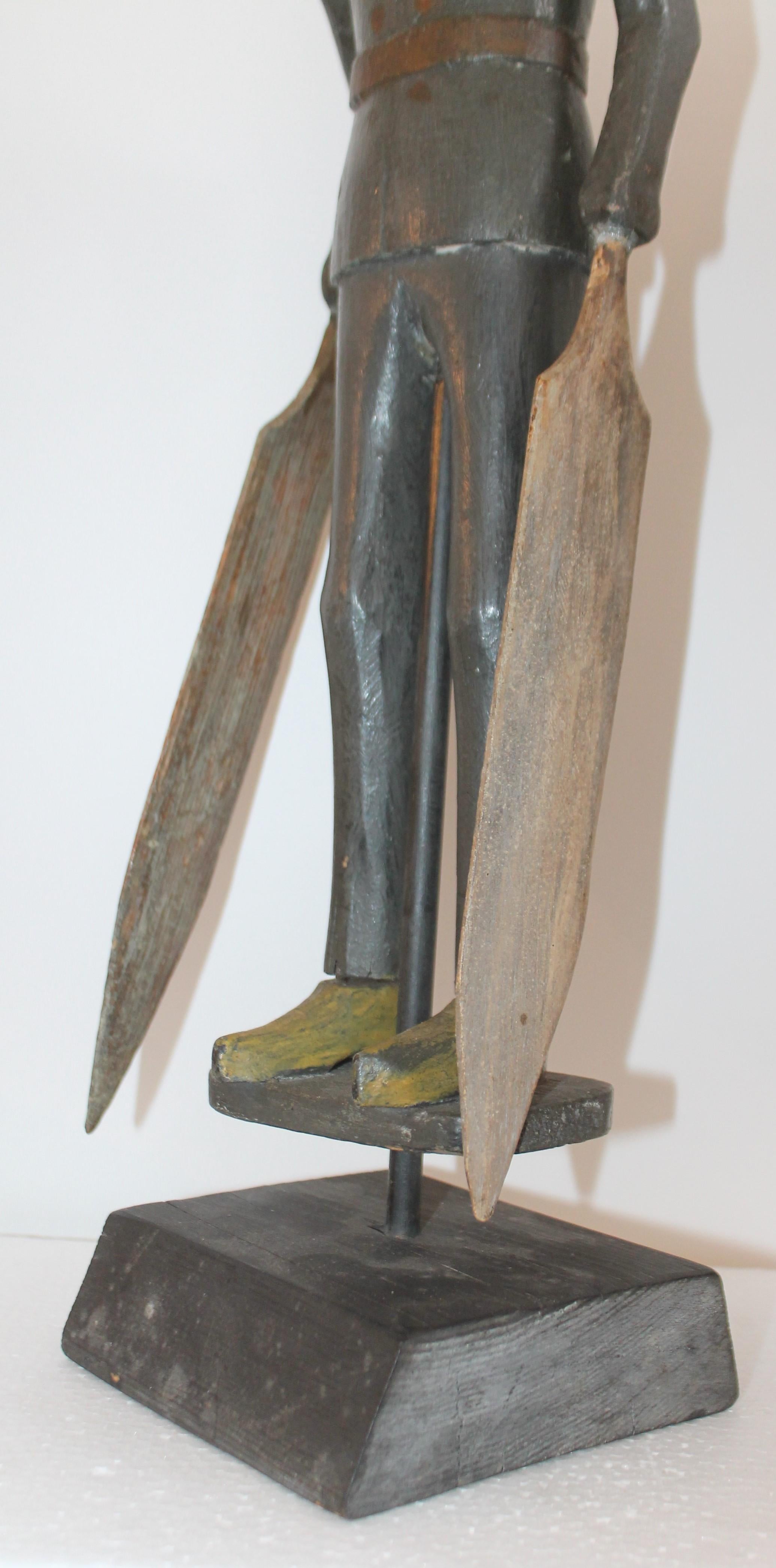 This amazing original painted Folk Art whirligig of a soldier is in good condition and on a block of wood that is its stand. The original blades have been re-glued at one time, but are also original to the piece. The carving is very crude with a