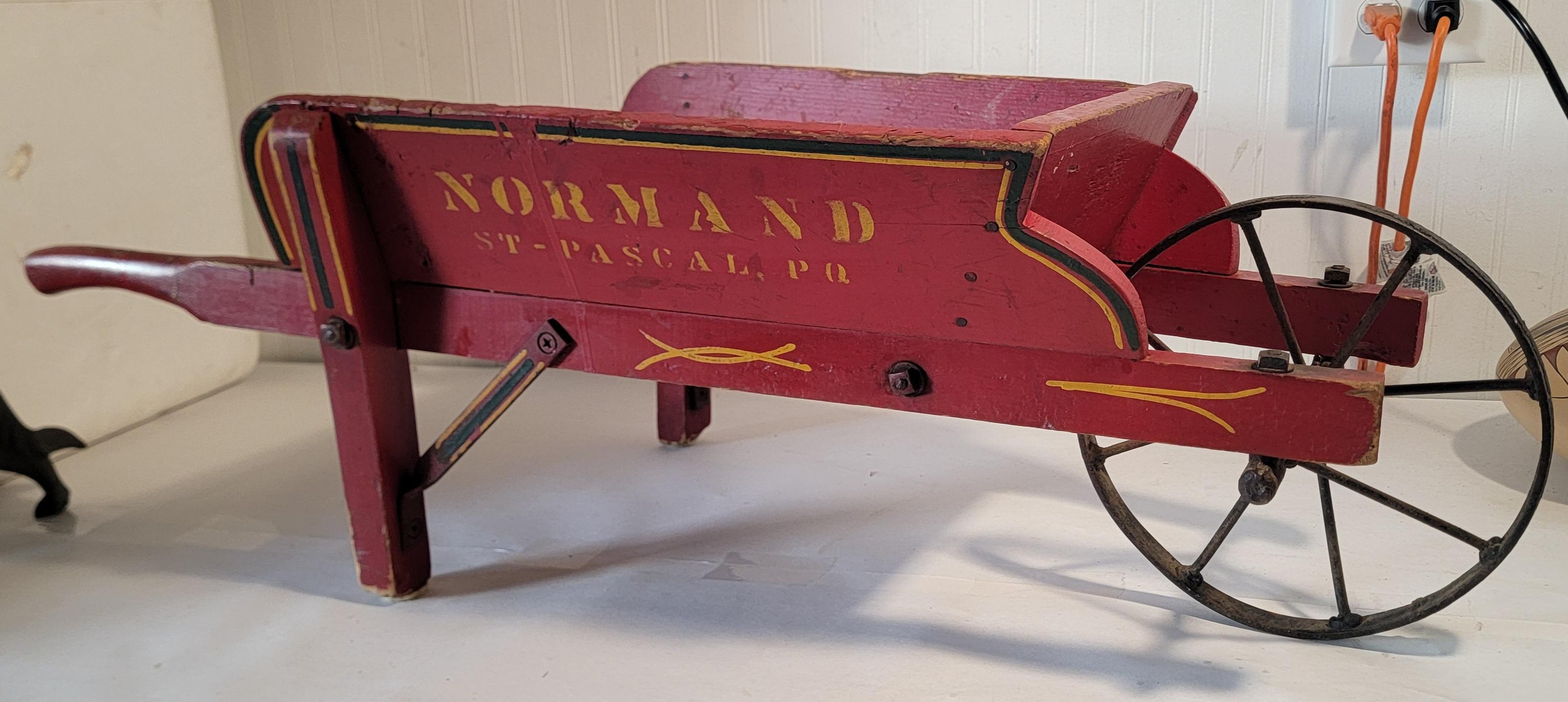 Normand St-Pascal, PQ Found in Pennsylvania, This Original red painted wheel barrel has a mustard stenciling.