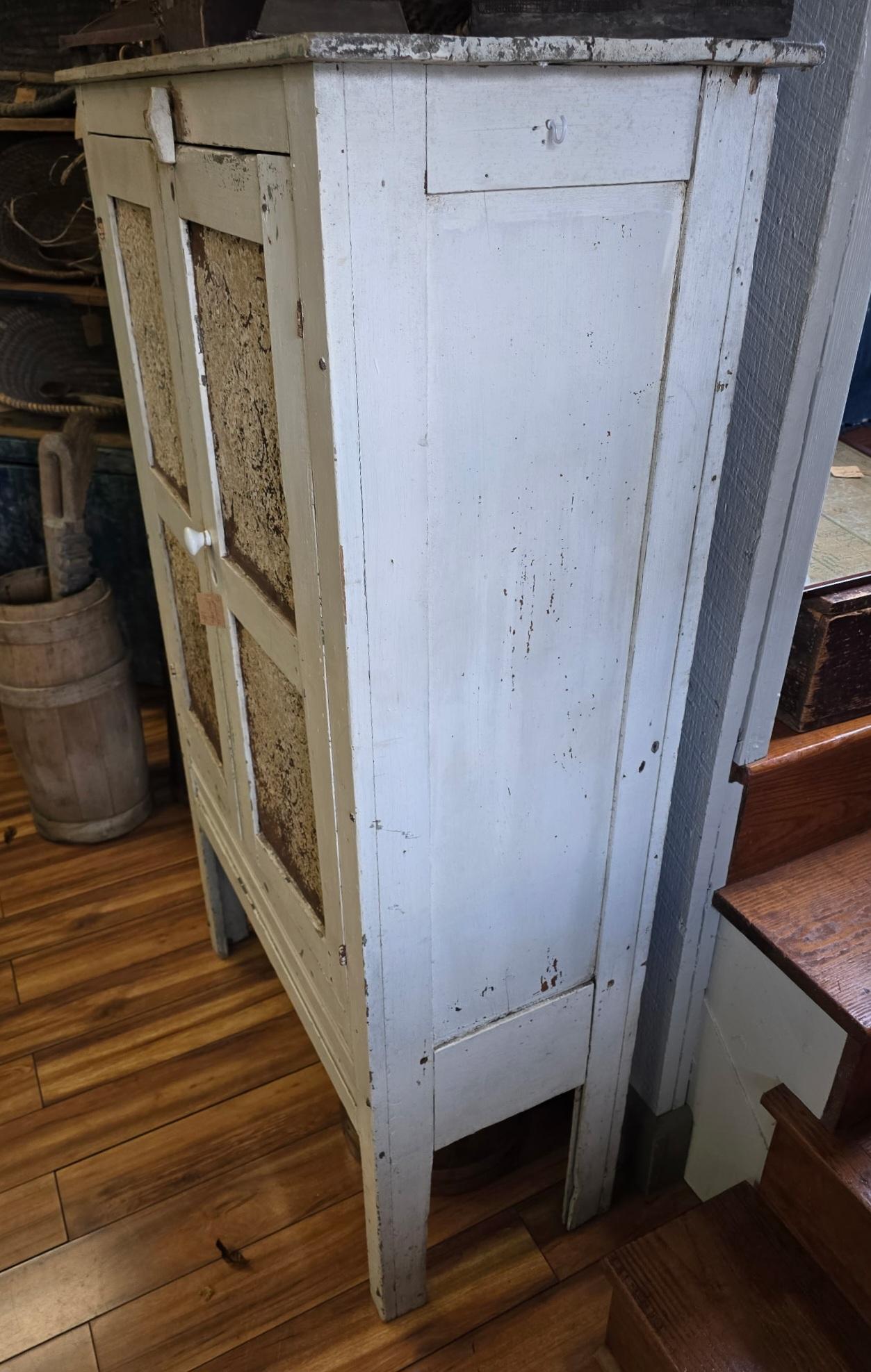 This amazing original  white painted pie safe cupboard is in great condition with four punched tins in double doors.The interior is also the same white painted shelf's and interior. Notice all original hardware and square nail construction.