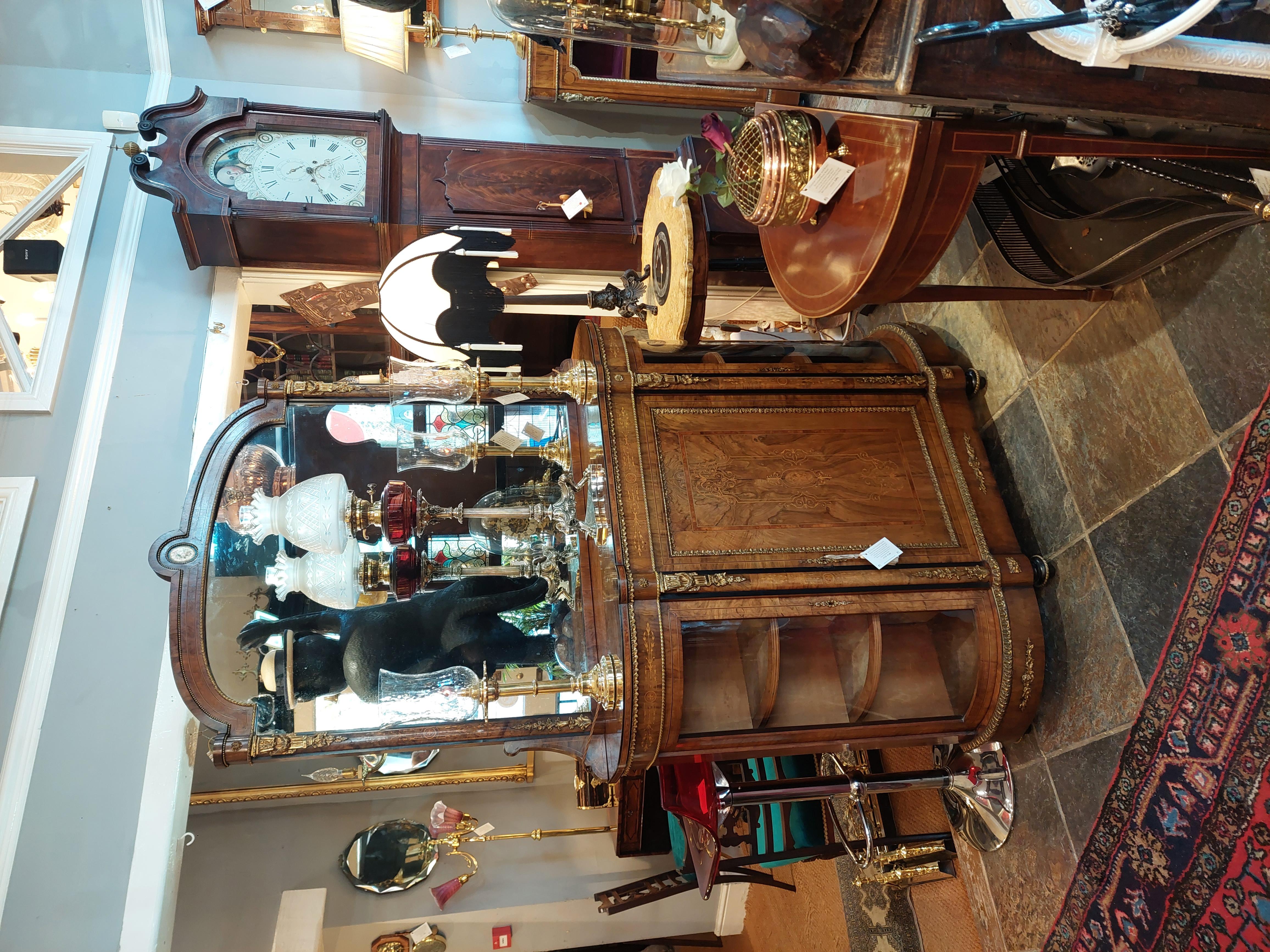 19thC Ormolu Mounted Figured Walnut Mirror Back Credenza the shaped mirror with Sèvres-style porcelain panel inset above a bow-sided base with glazed doors enclosing display shelves flanking a centre panelled door fronting a shelved interior; on