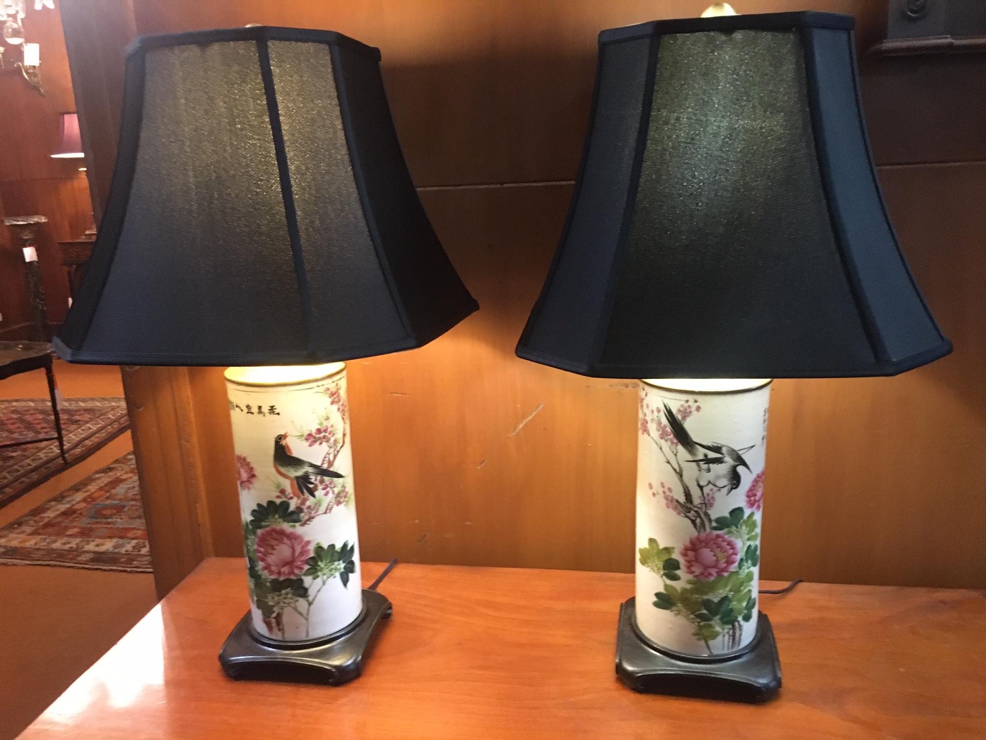 These colorful 19thc hand-painted porcelain vases have been converted into lamps with decorative scrolled teak bases and custom shades. Each vase features a different delicately painted song bird perched among detailed flowers and blossoms. Chinese