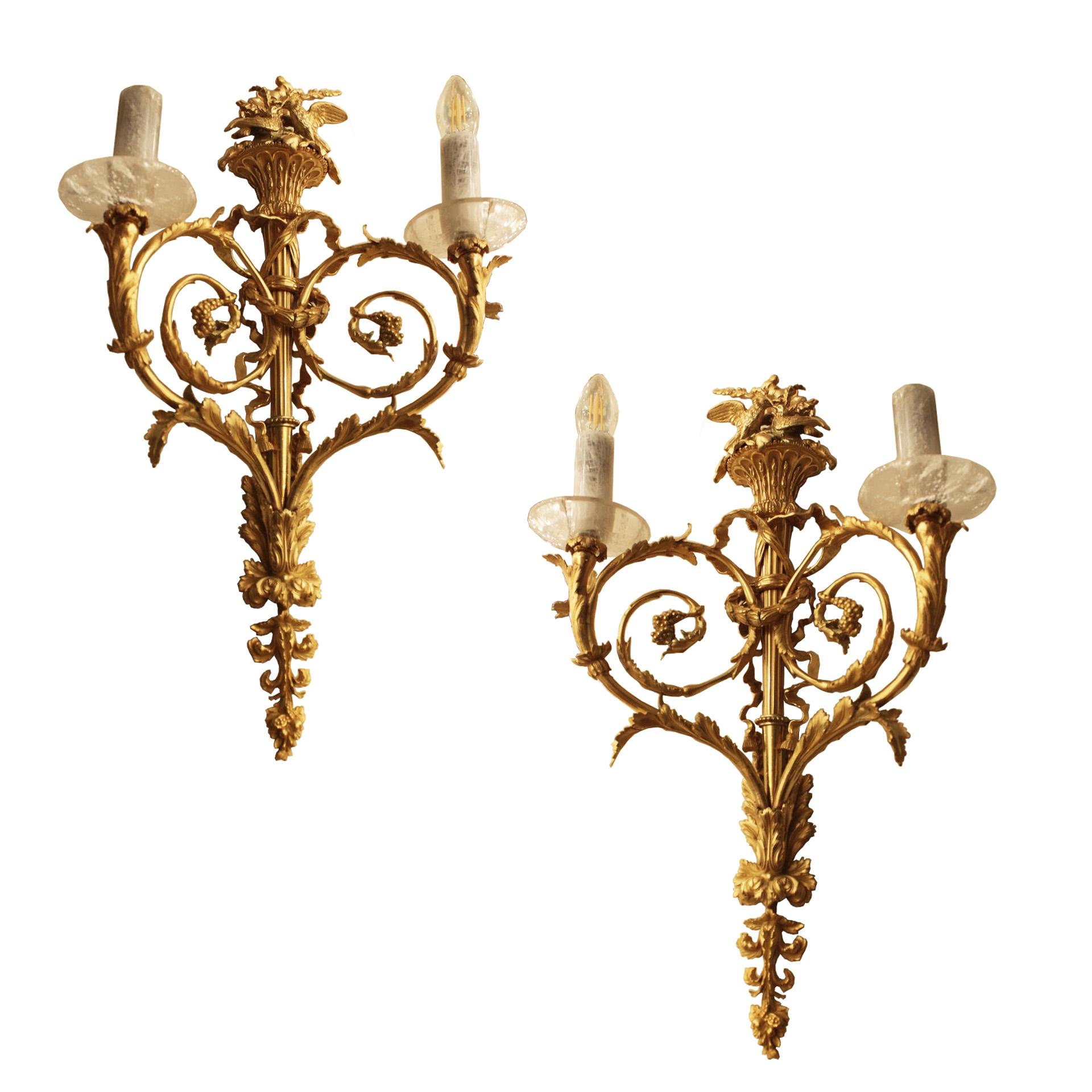 Exclusive 19th century pair of bronze French wall lights with lovely birds, decorative arms, each wall light has two lights. Each features rock crystal bobeche and candle tubes.  Could be further embellished with rock crystal drops beneath each arm