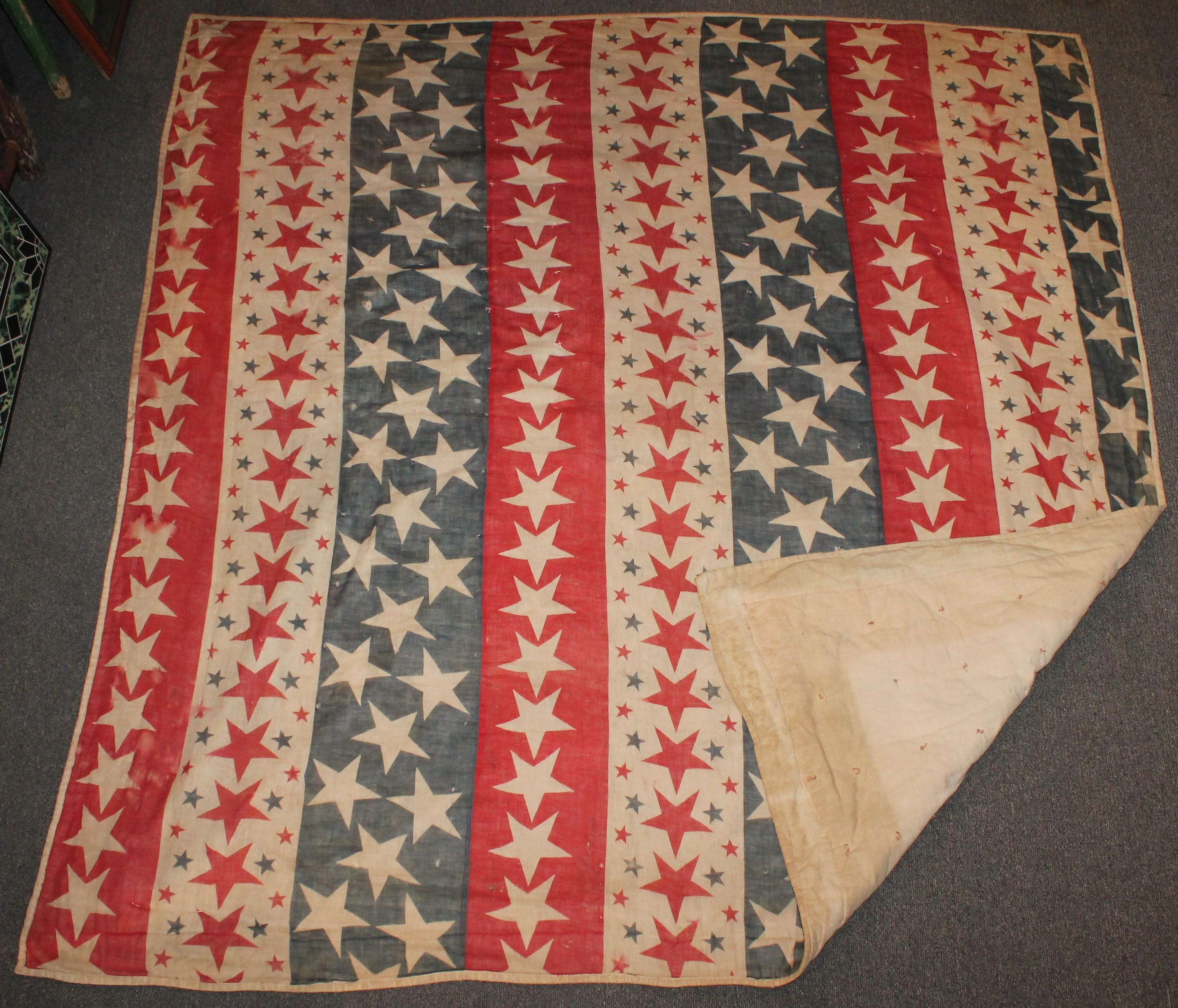 19th century Patriotic bunting red, white and blue stars tied quilt. It is dated on the feed sack back 1898. This quilt has some minor wear holes and spotting on the reverse but in pretty good condition other wise.