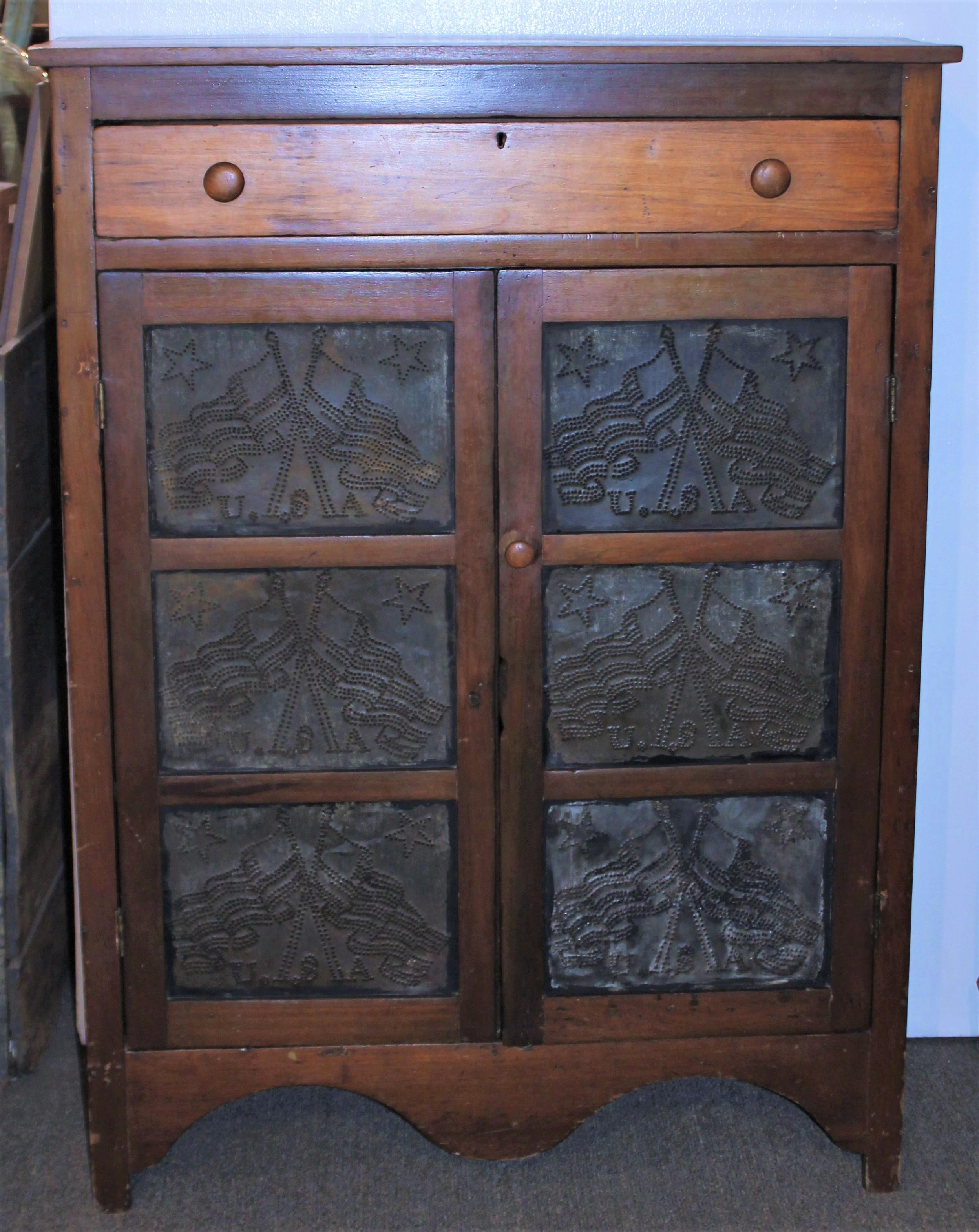 19th c punched tins cross flags pie safe all original and a natural old surface. This safe was found in East Tennessee and is in fine condition. The condition is very good and it is in working order. At one time this was probably painted and is in a