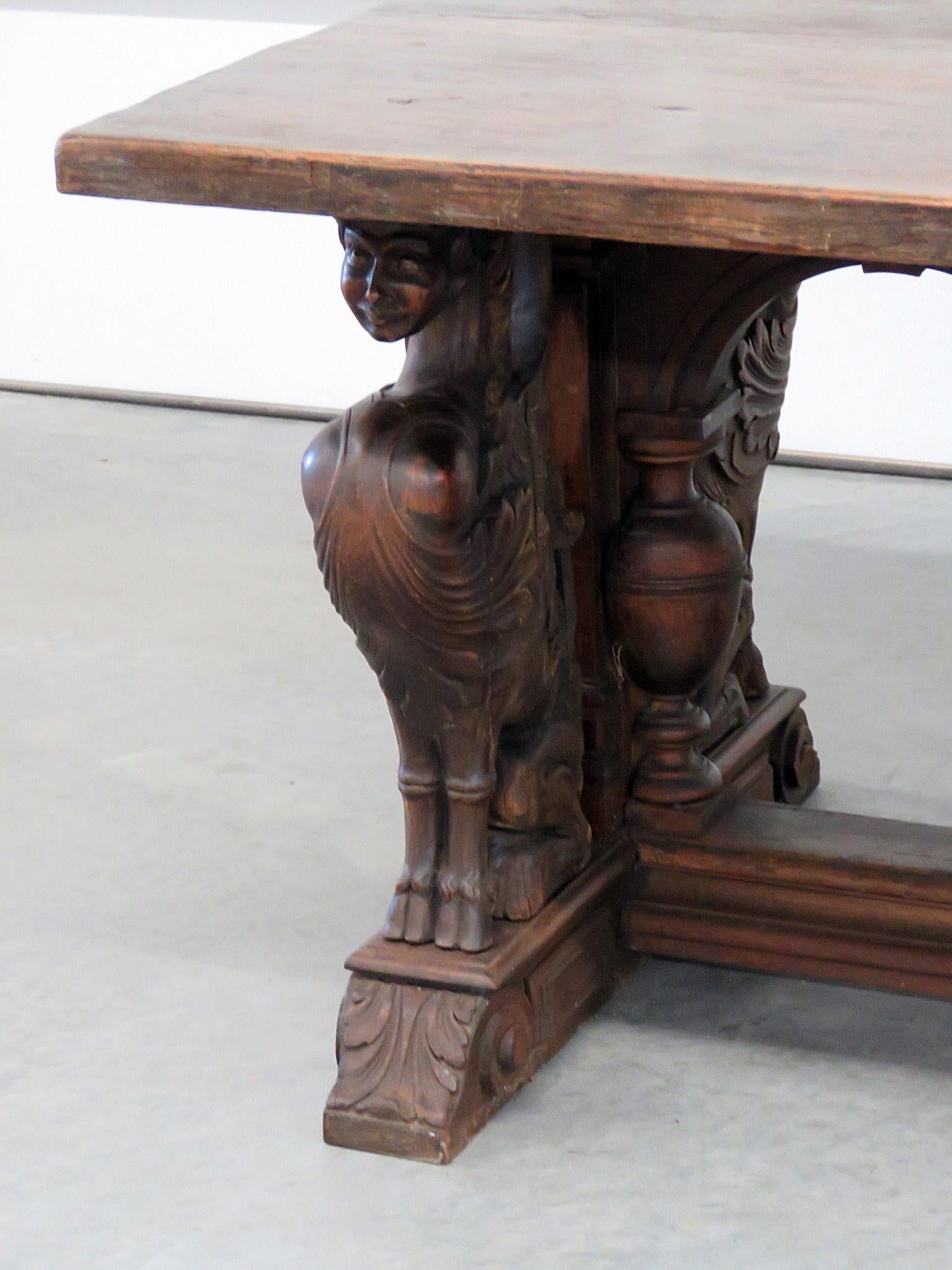 Antique 19th century Renaissance style carved winged griffin dining table.