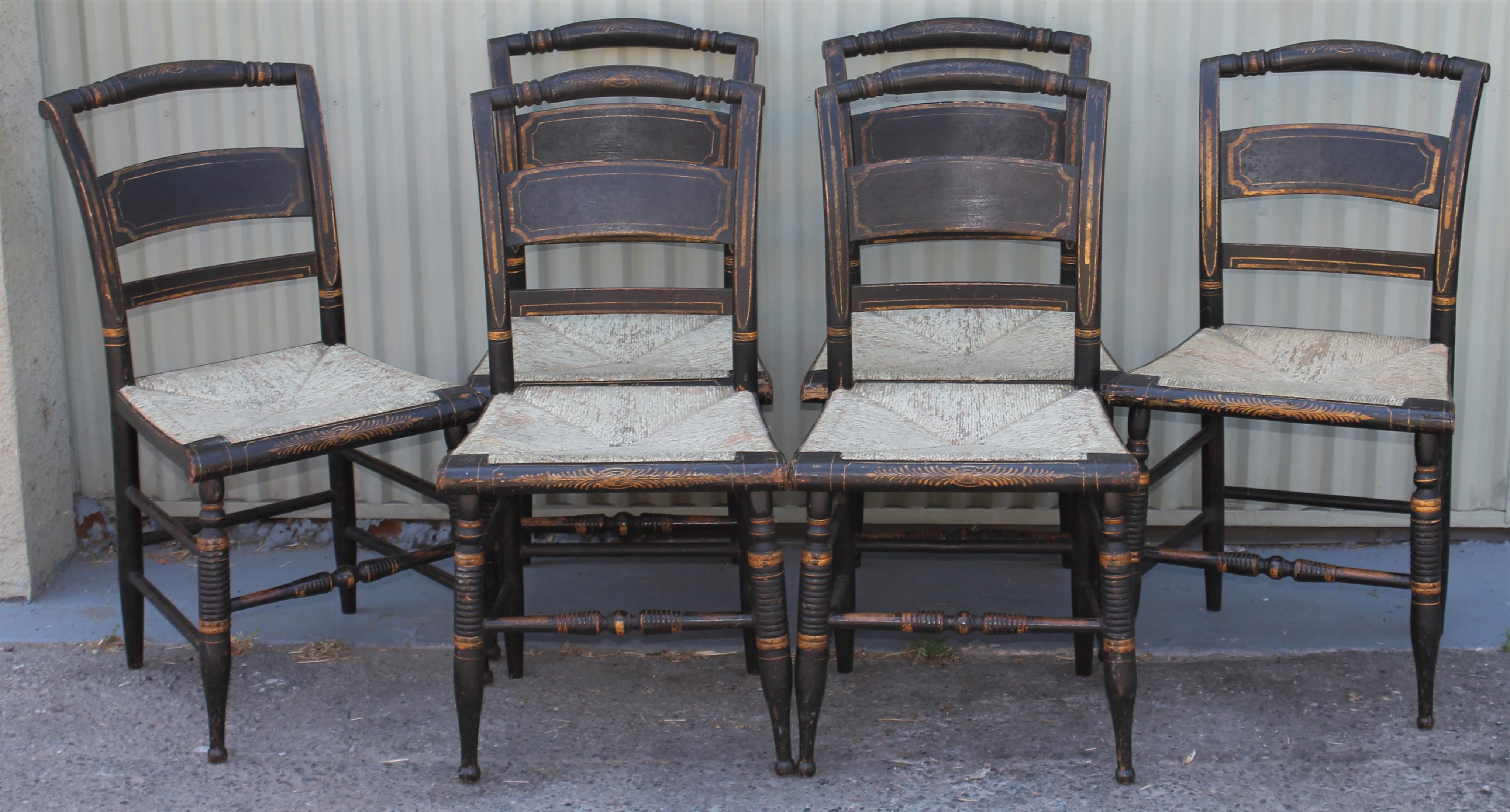 This fine set of six Hitchcock chairs in all original painted surface and very sturdy condition. The detail in the gilded stencil is pristine and white painted hand woven rush seats. The condition is very good and sturdy.