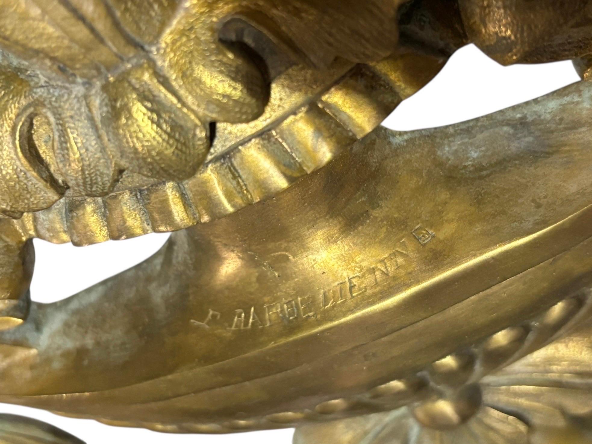 Mid 19thC Barbedienne signed pair of neoclassical period three arm sconces in bronze, made in France. Three foliate arms are decorated with floral swags. The fluted oval back plate is surmounted with a typical neoclassical grecian inspired vase