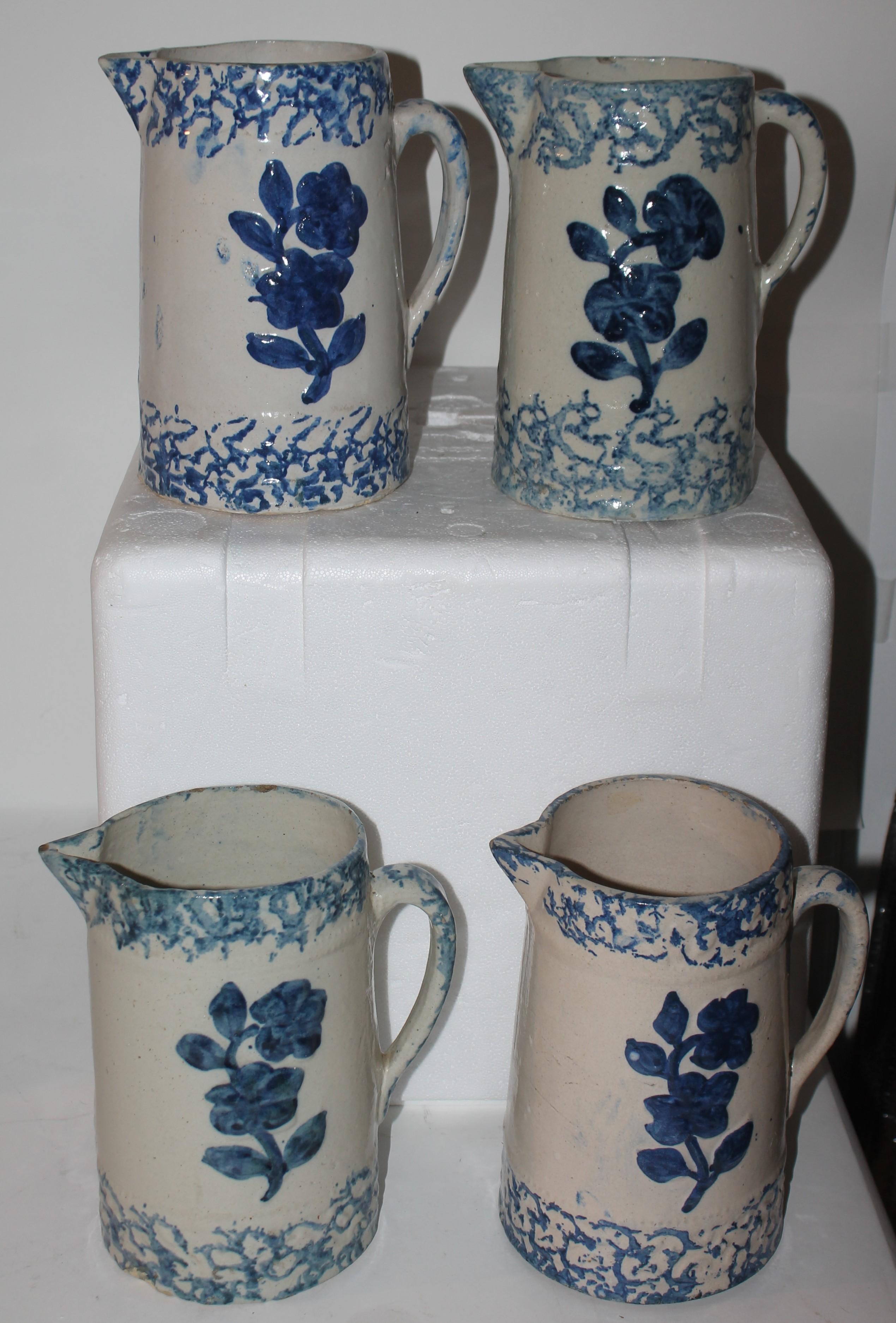 These 19th century handmade and painted floral faced sponge ware pottery pitchers are in fine condition. Each pitcher measures 7 x 5 x 9. Sold as a group of four.