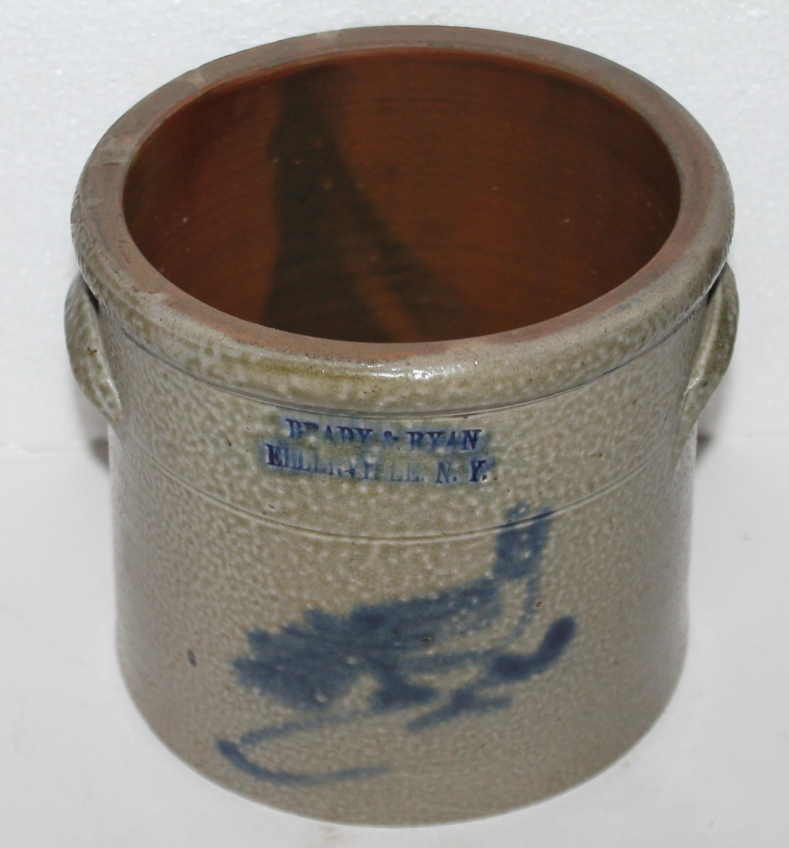 This fine double handled stoneware crock with a bird decoration on the front of the crock is in fine condition. The maker is Brady & Ryan from Ellenville, New York. This fine small beauty is in pristine condition.