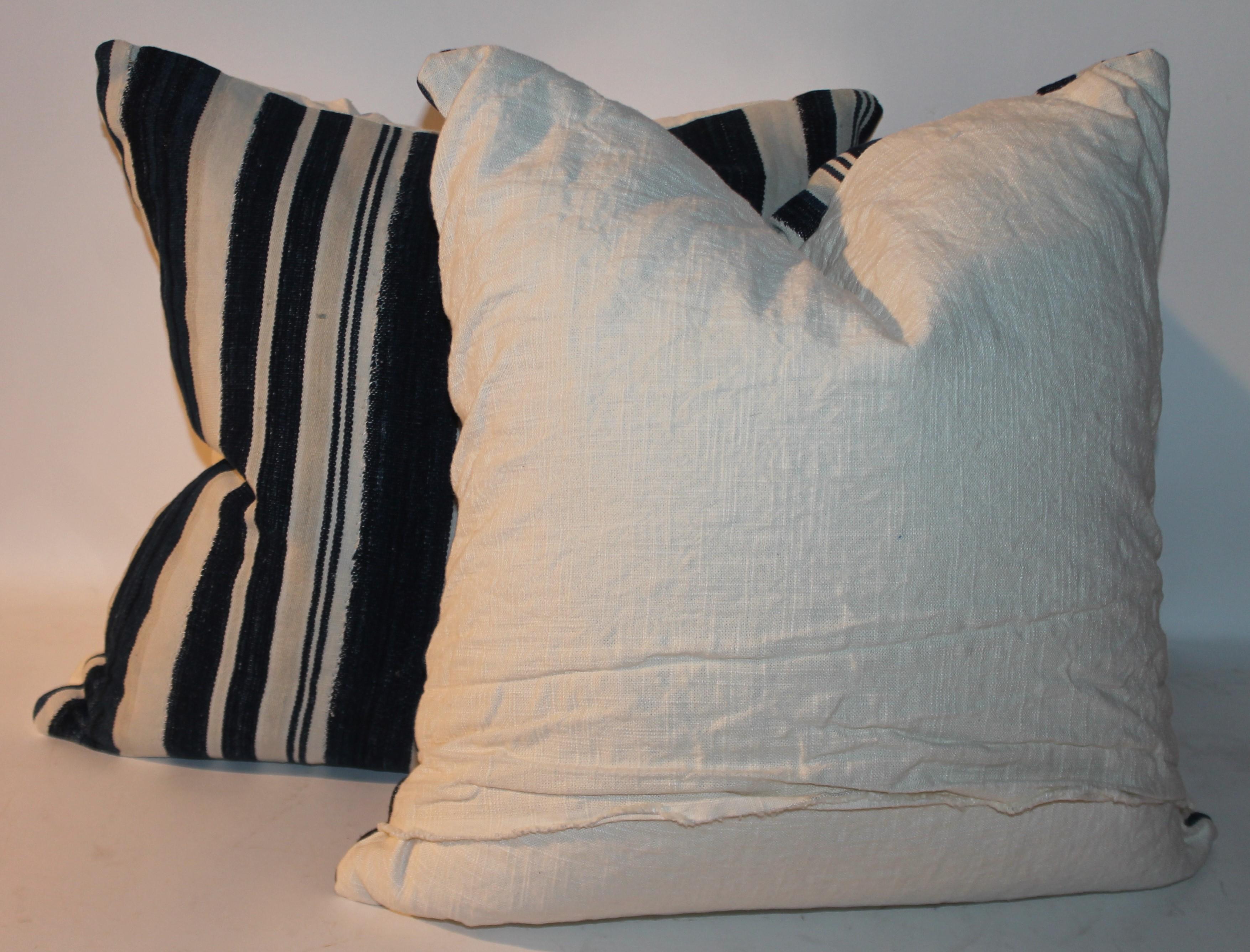 These fine indigo striped linen pillows are in fine condition and have white linen backing. They are all cotton and are down & feather fill.