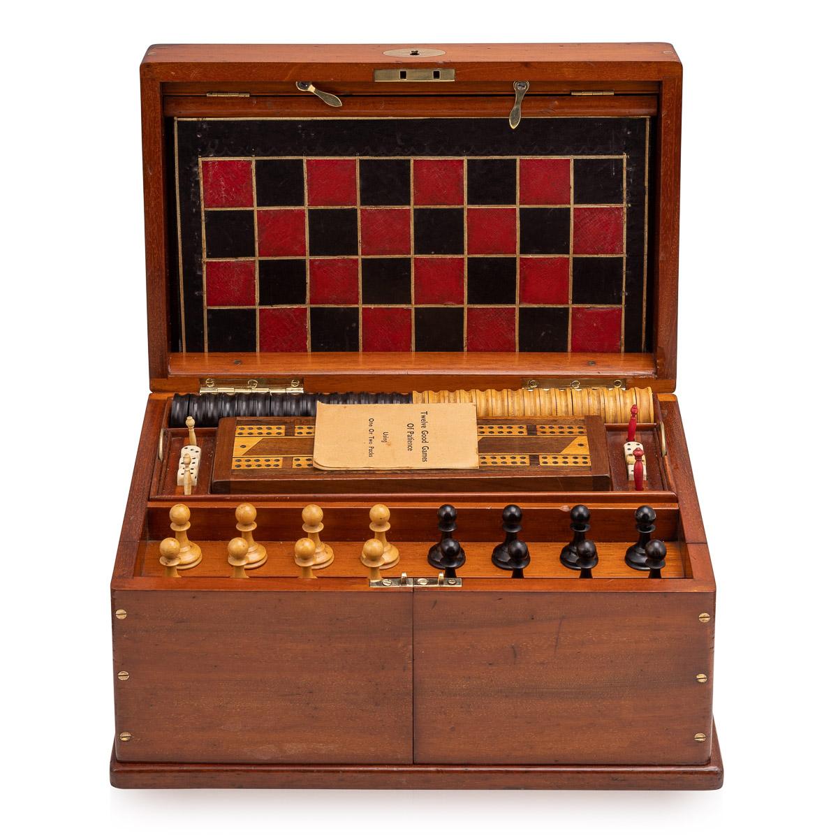 Antique late 19th century Victorian mahogany cased games compendium, the interior comprising a boxwood and ebony chess set, Draughts, dominoes, dice, cribbage board with markers, leather bound boards for games, playing cards, gavel, droughts
