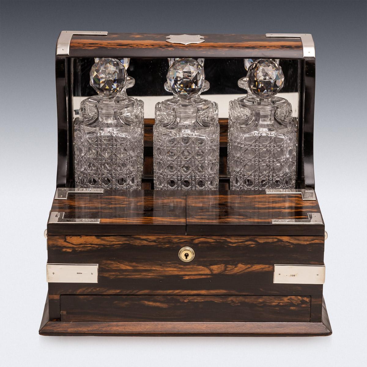 Antique late 19th century Victorian solid silver mounted on Coromandel Tantilus, humidor and games compendium, the interior comprising three cut crystal decanters with stoppers, four glasses, a secret hidden draw, which opens by first opening the