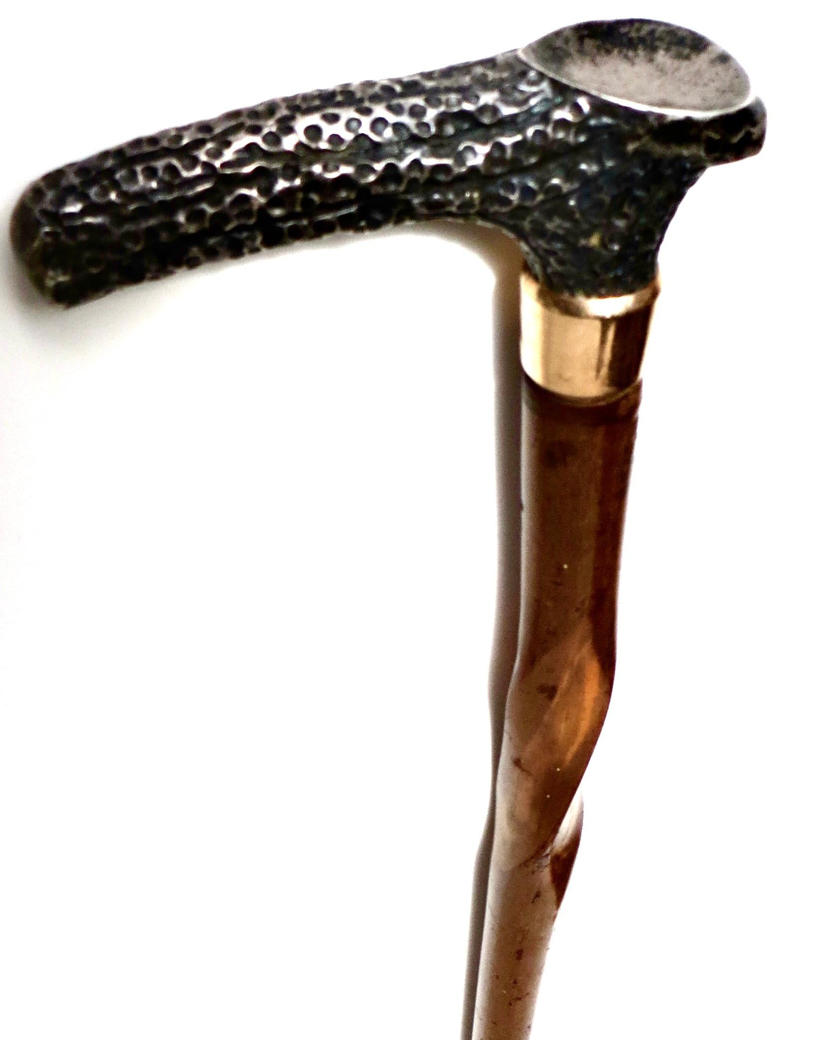 Questo bastone da passeggio vittoriano del XIX secolo, intagliato a mano in legno duro di prima qualità (probabilmente pecan), presenta un design a torsione continua. La parte superiore è decorata con un motivo di simulazione di corna o corni in