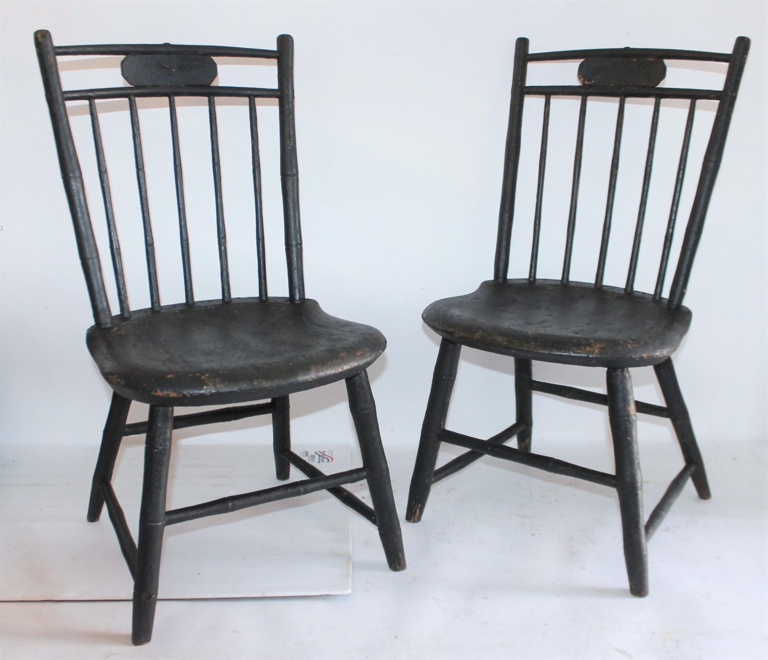 19th century original black painted children's chairs in fantastic condition. These wonderful handmade Windsors have saddle seats and were found in New England. Its so wonderful to have a matched pair of Children's Windsors in old black painted