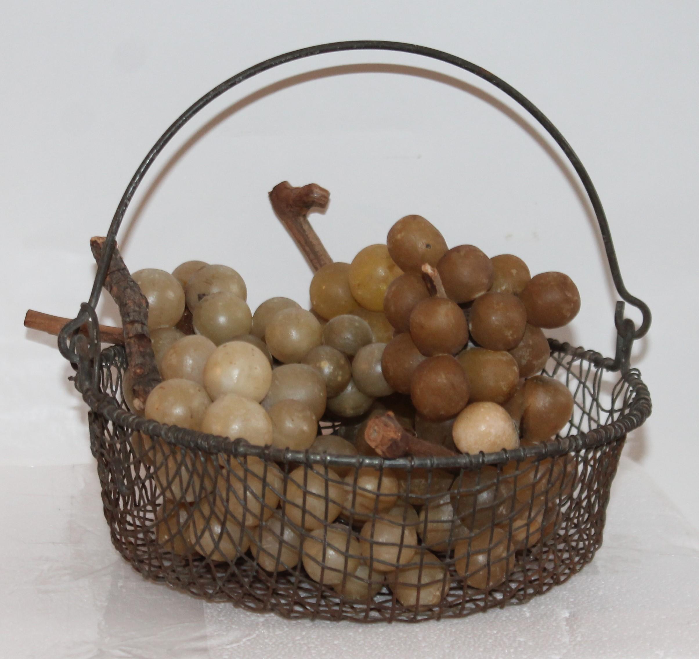19th century wire handled basket filled with collection of six bunches of alabaster grapes. All in very nice condition.
