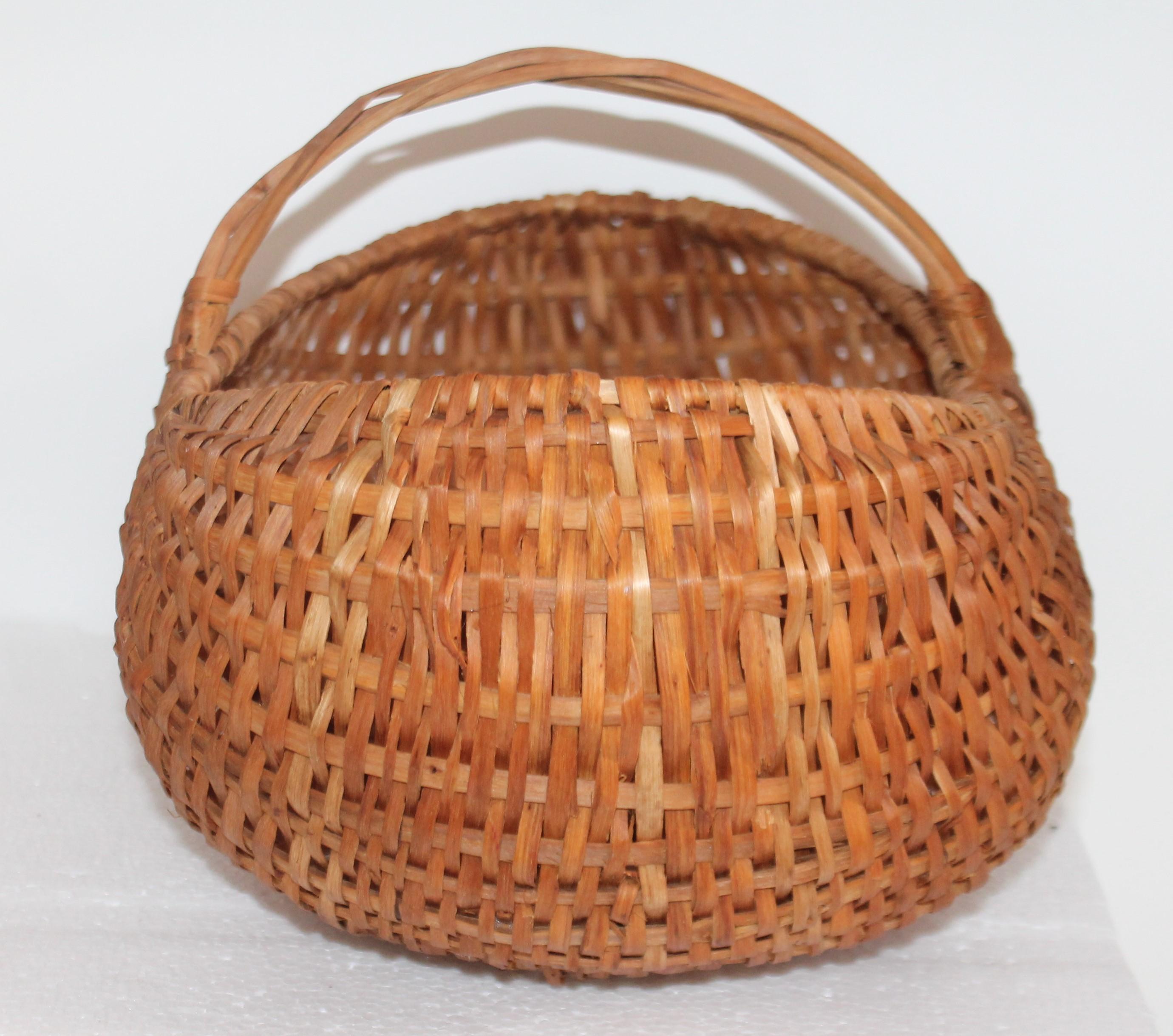 Questo bel cesto di natiche naturali dalla superficie tutta originale. Cestino in legno di hickory intrecciato a mano con manico ritorto. Le condizioni sono ottime.