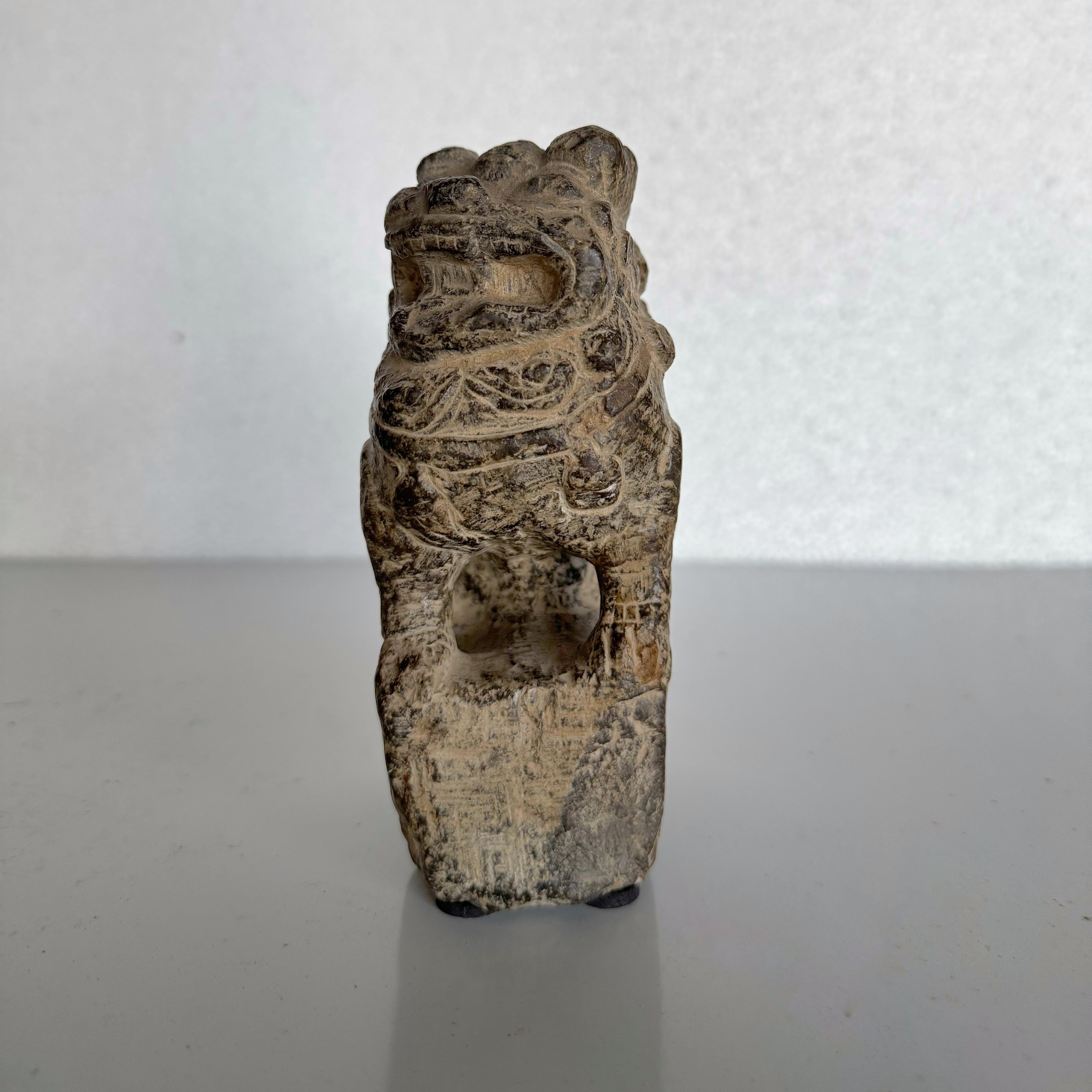 Un lion antique en pierre à l'expression charmante provenant de la province de Shanxi, en Chine, dont l'âge est estimé à 150-200 ans. Contrairement aux lions gardiens traditionnels placés par paires aux entrées, il s'agit ici d'un lion de bureau
