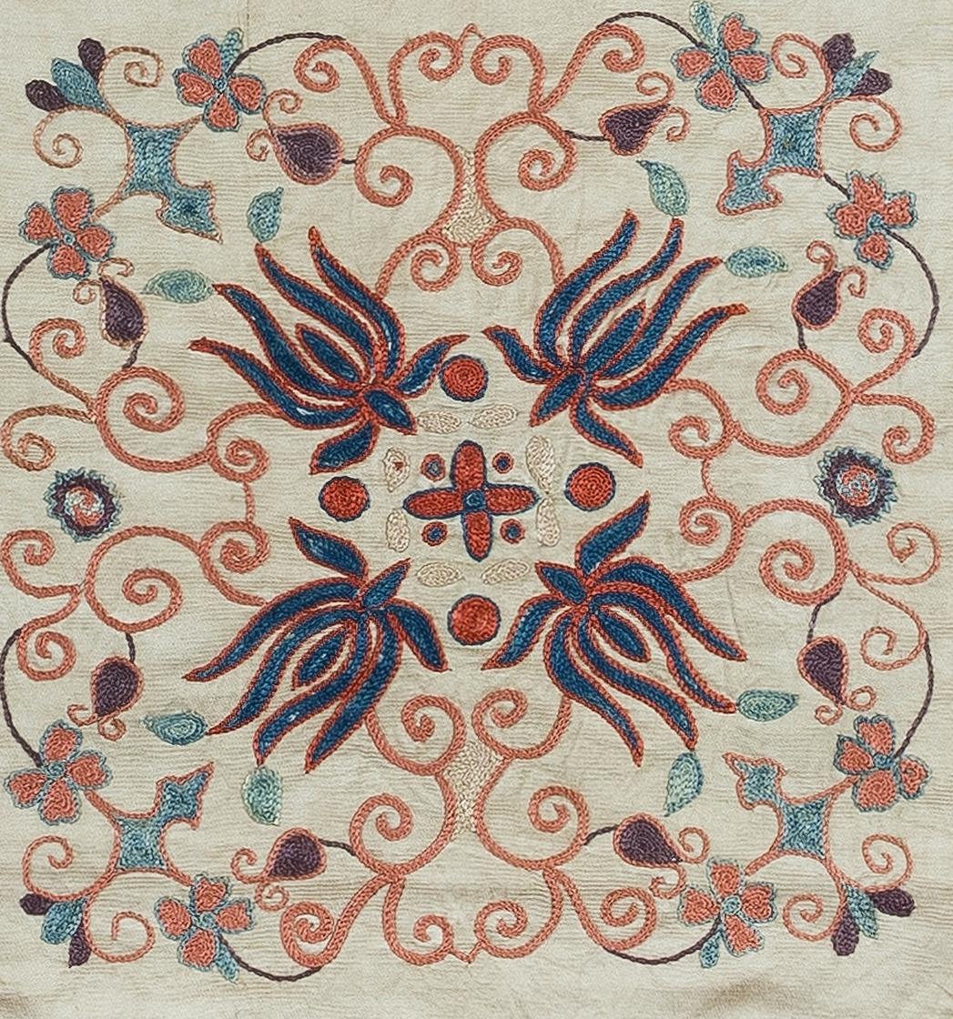 Housse de coussin décorative en soie brodée à la main sur fond de soie, motifs de fleurs et de vignes, support en lin avec fermeture à glissière, pas d'insert.

Lavage délicat et spécialisé conseillé.

Le suzani est un type de panneau textile tribal