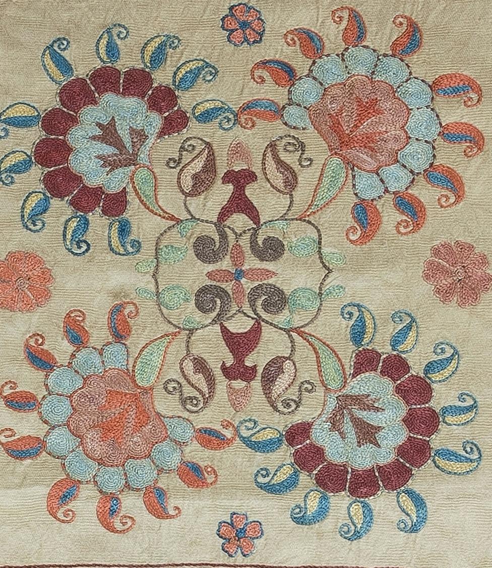 Dekorativer Suzani-Kissenbezug mit handgestickter Seide auf Seidengrund, Blumen- und Rankenmotiven, Leinenrückseite mit Reißverschluss, ohne Einlage.
Empfohlene Fein- und Spezialwäsche.
Suzani, ein zentralasiatischer Begriff für eine bestimmte Art