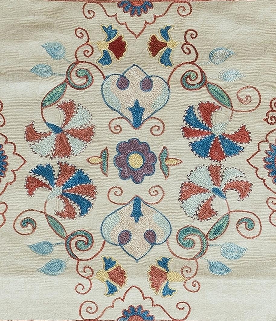 Housse de coussin décorative en soie brodée à la main sur fond de soie, motifs de fleurs et de vignes, support en lin avec fermeture à glissière, pas d'insert.

Lavage délicat et spécialisé conseillé.

Le suzani est un type de panneau textile tribal