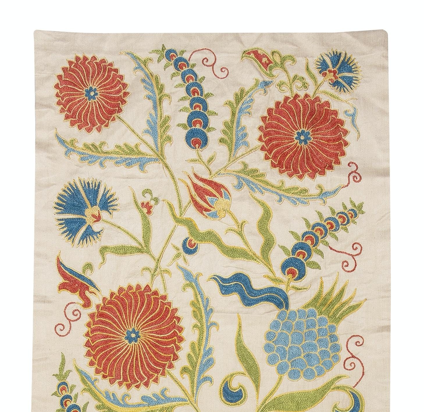 Zelebrieren Sie das reiche Erbe asiatischer Handwerkskunst mit diesem exquisiten Suzani-Textil aus 100 % Seide, das von erfahrenen Kunsthandwerkern sorgfältig von Hand bestickt wird. Dieses wahre Kunstwerk verkörpert eine jahrhundertealte Tradition