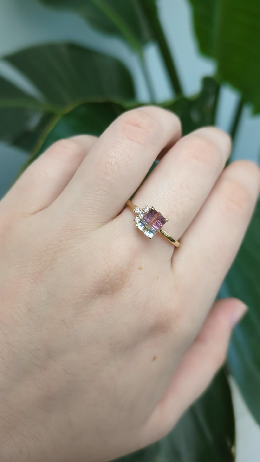 Questo delicato anello mette in mostra una tormalina bicolore con taglio a smeraldo da 1,00 carati proveniente dal Brasile, nota per la sua unica suddivisione naturale dei colori. Incastonata in oro 14k (1,76g), la vibrante pietra centrale è