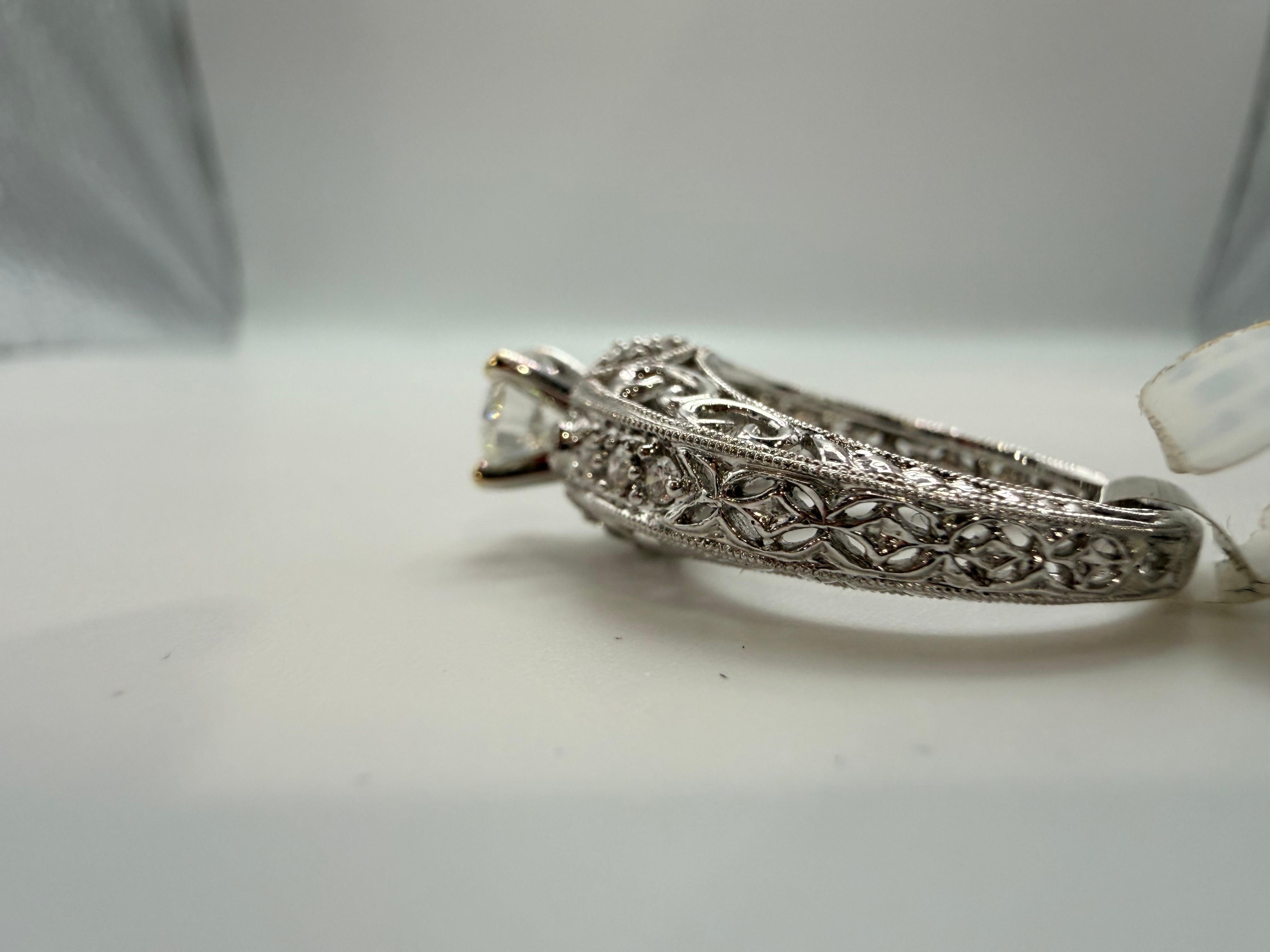 Verlobungsring aus 18 Karat Weißgold mit 1 Karat Diamant in der Ringmitte und 0,40 Karat kleineren Diamanten. Alle Diamanten haben die Reinheit VS-SI und die Farbe F-G. Dieser Ring ist aufwendig und man merkt, dass die Juweliere viel Zeit in die