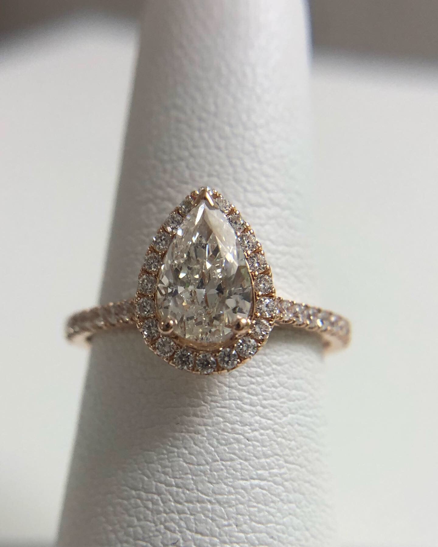 Elegant engagement ring made with 1ct pear brilliant in the center, SI3 clarity and G color, ring is made in size 7 and can be adjusted, the metal is 14KT rose gold. The small round diamonds are totalling 0.40ct and are SI clarity and G color. Ring