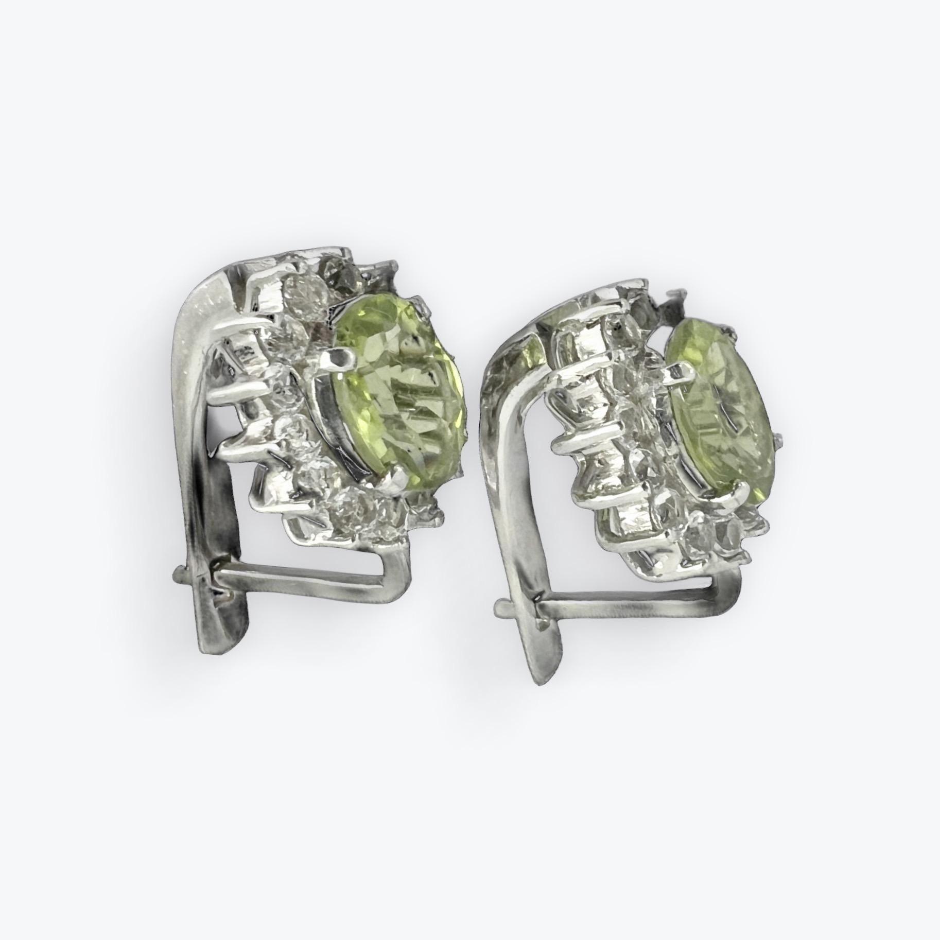 Add a touch of vibrant elegance to your ensemble with our stunning 1ct each Oval Peridot Earrings. Each earring features a mesmerizing oval mint green peridot gemstone, surrounded by sparkling white natural zircon accents, creating a radiant and