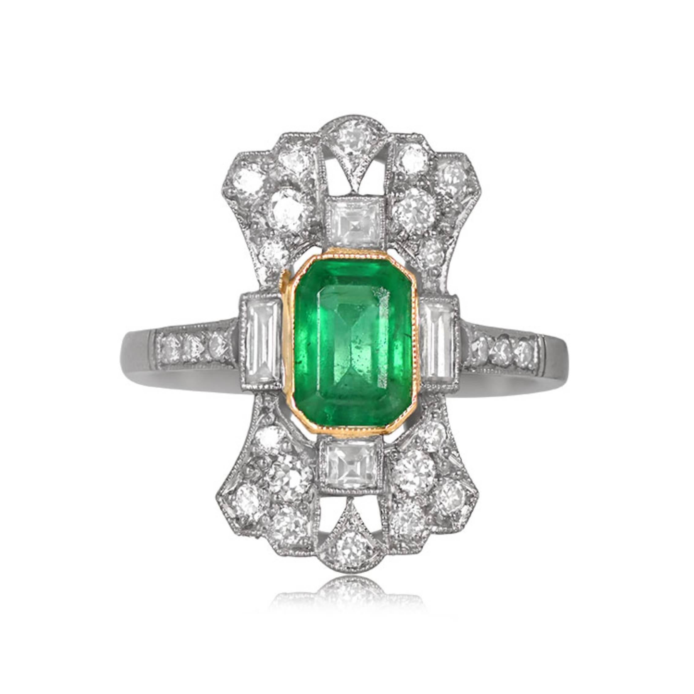 A captivating 1.00-carat natural Colombian emerald in an elongated emerald cut graces this exquisite platinum ring. The emerald's deep green saturation is complemented by antique diamonds. This unique piece is handcrafted in platinum, and the bezel