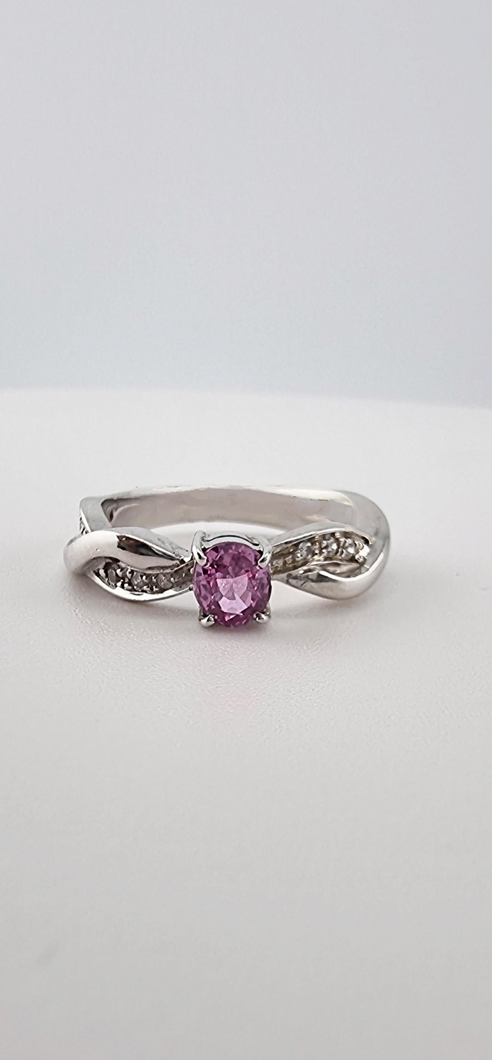 Our exquisite piece featuring a captivating 5.5x4.6mm oval natural origin pink sapphire, the centerpiece of this elegant design. This gemstone’s delicate blush pink hue makes it a standout choice for those who appreciate the pretty pink